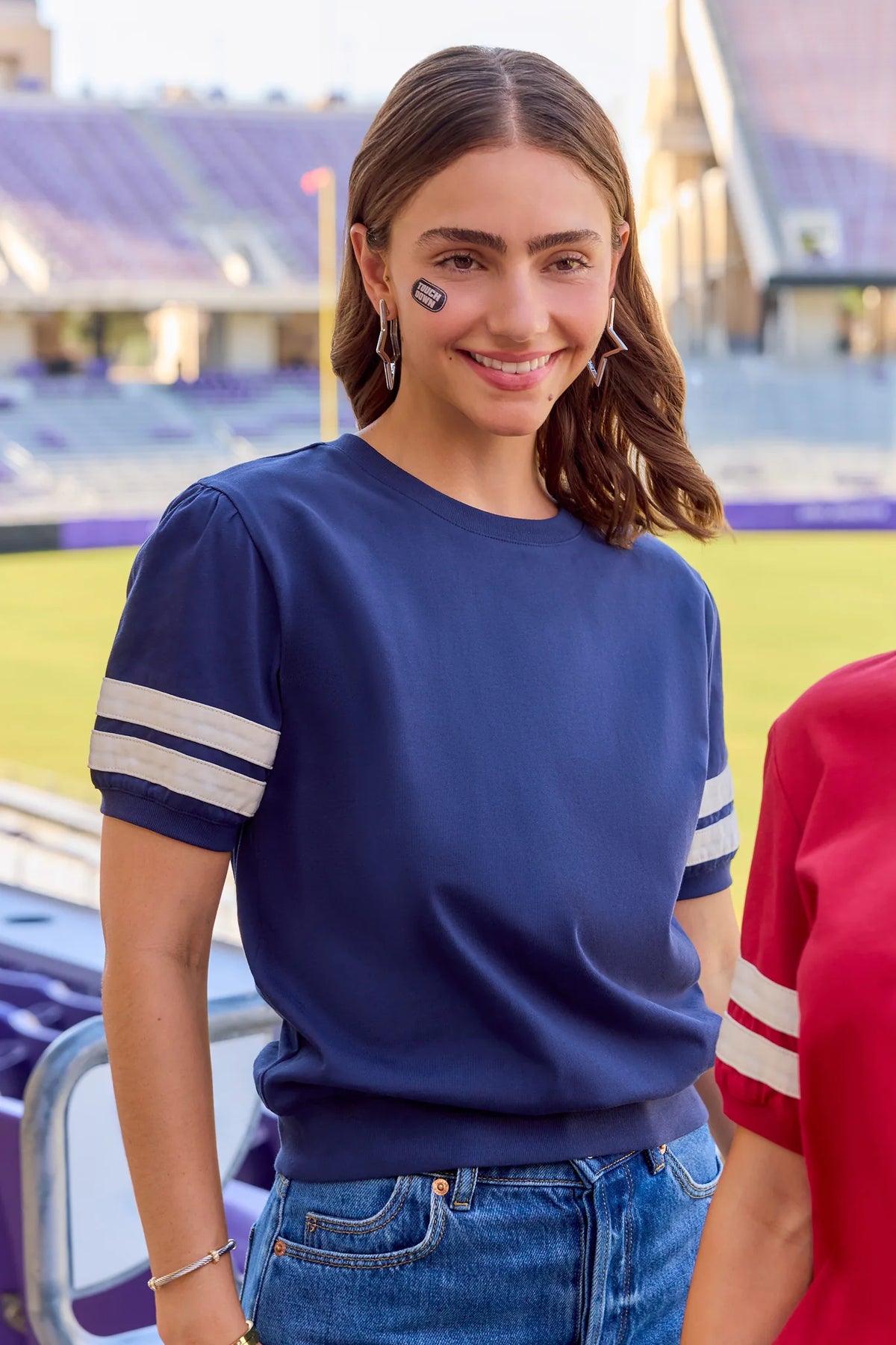 Alice Navy Striped Sleeve Tee styled for game day at a stadium, paired with denim | Avara