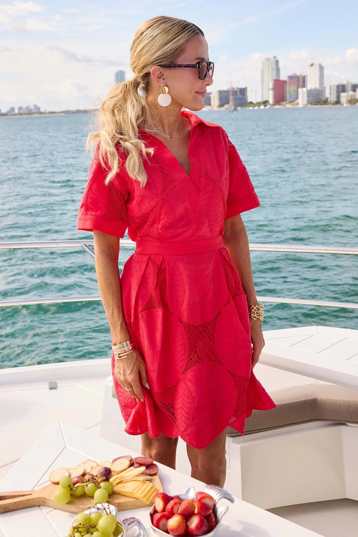 Annie Red Netted Short Dress styled on a yacht with city skyline - Lifestyle | Avara