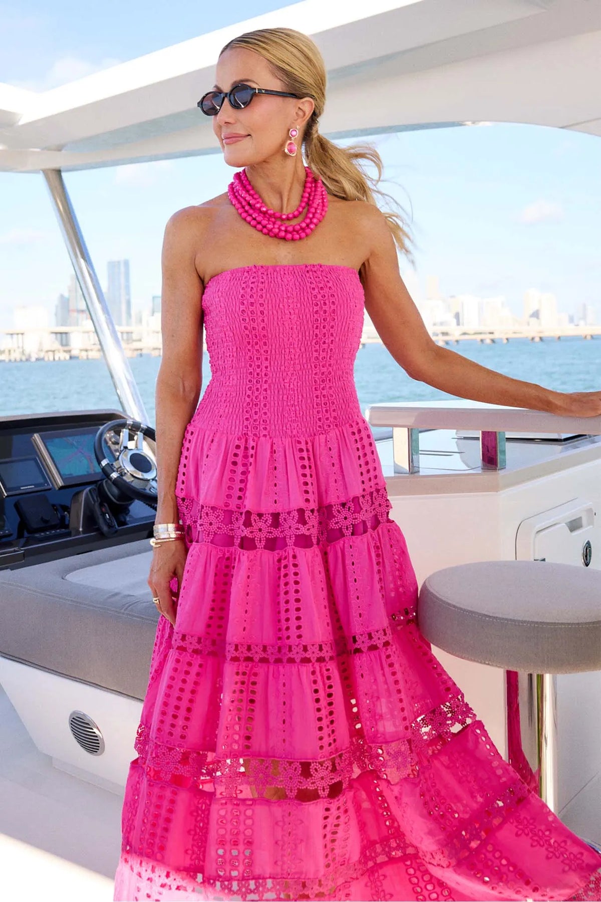 Hot pink strapless midi dress with eyelet embroidery, styled on a boat — Cecilia Dress | Avara