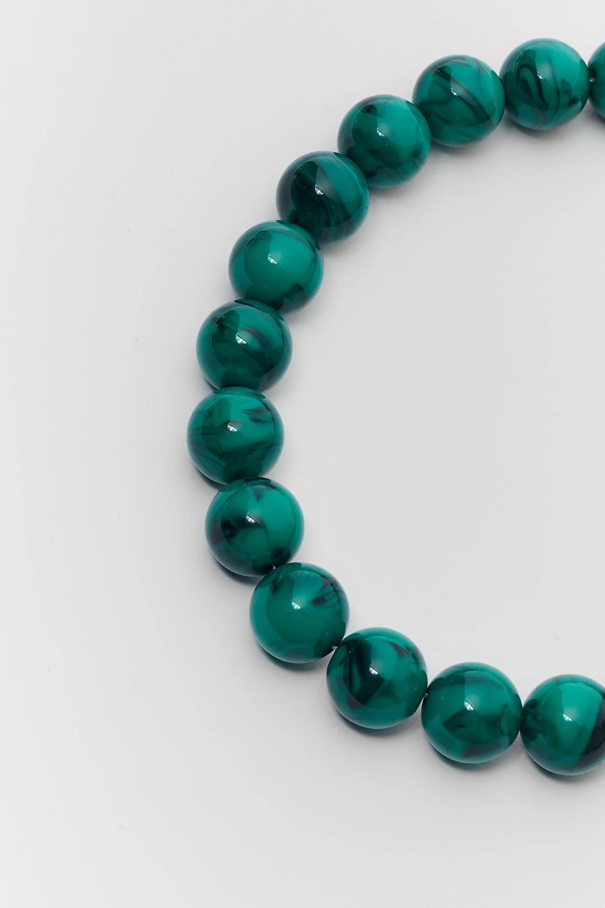 Close-up of chunky green beaded necklace showing glossy marbled round beads - Bead Detail | Avara