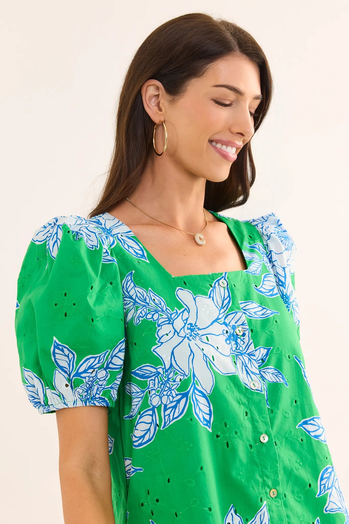Close-up of green eyelet floral short dress showing square neckline, puff sleeve detail, and button front | Avara