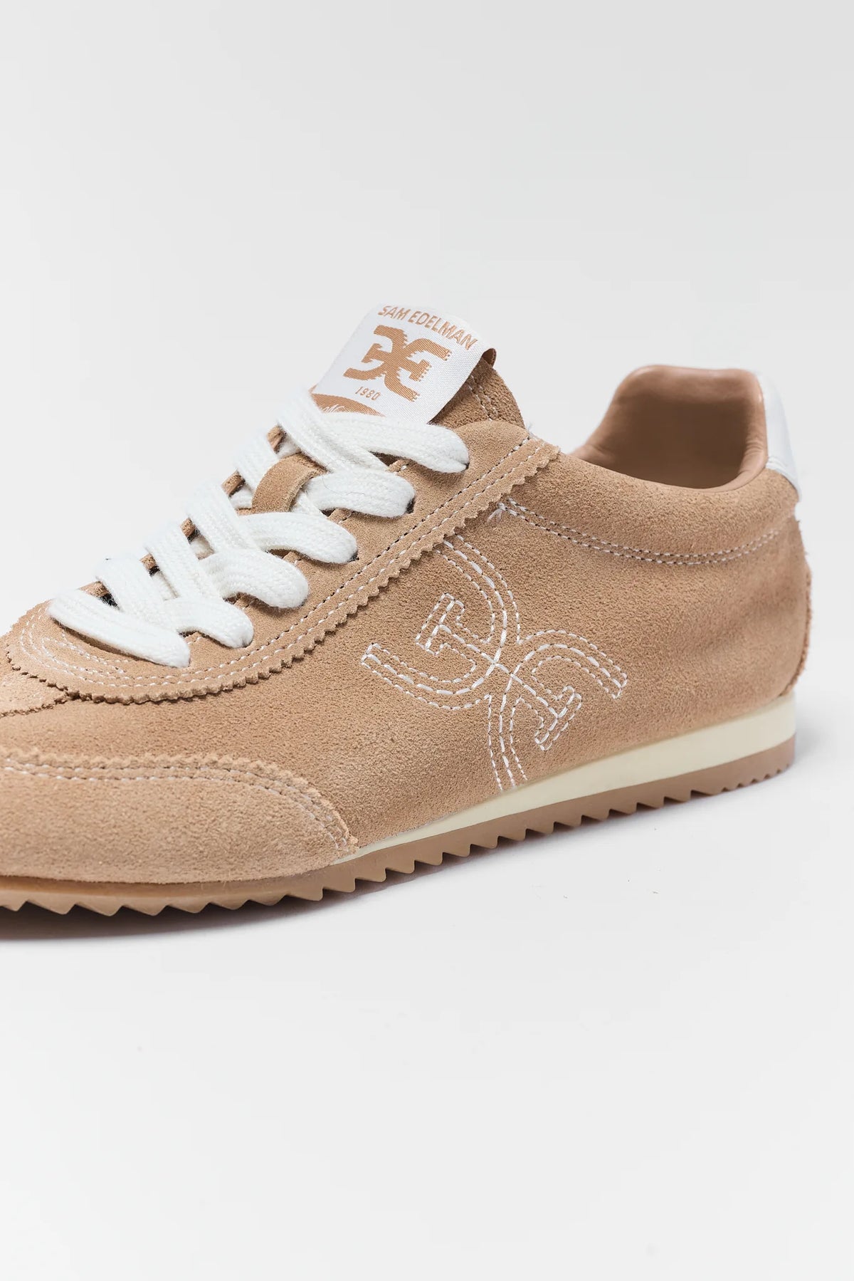 Tan Suede Isella Sneaker - Embroidered Logo Close-Up Detail | Avara
