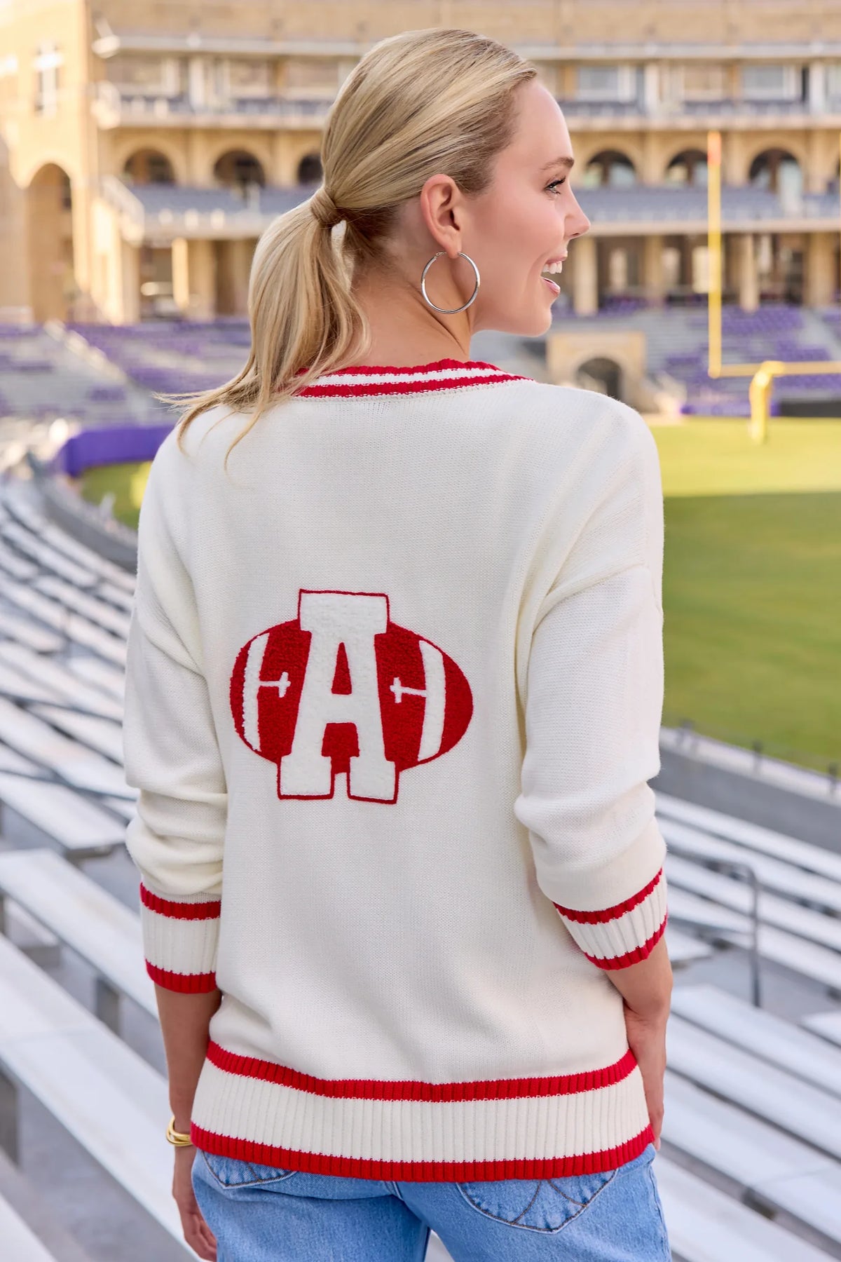 Jenna Ivory Applique Cardigan back view showing red football graphic, worn at stadium | Avara