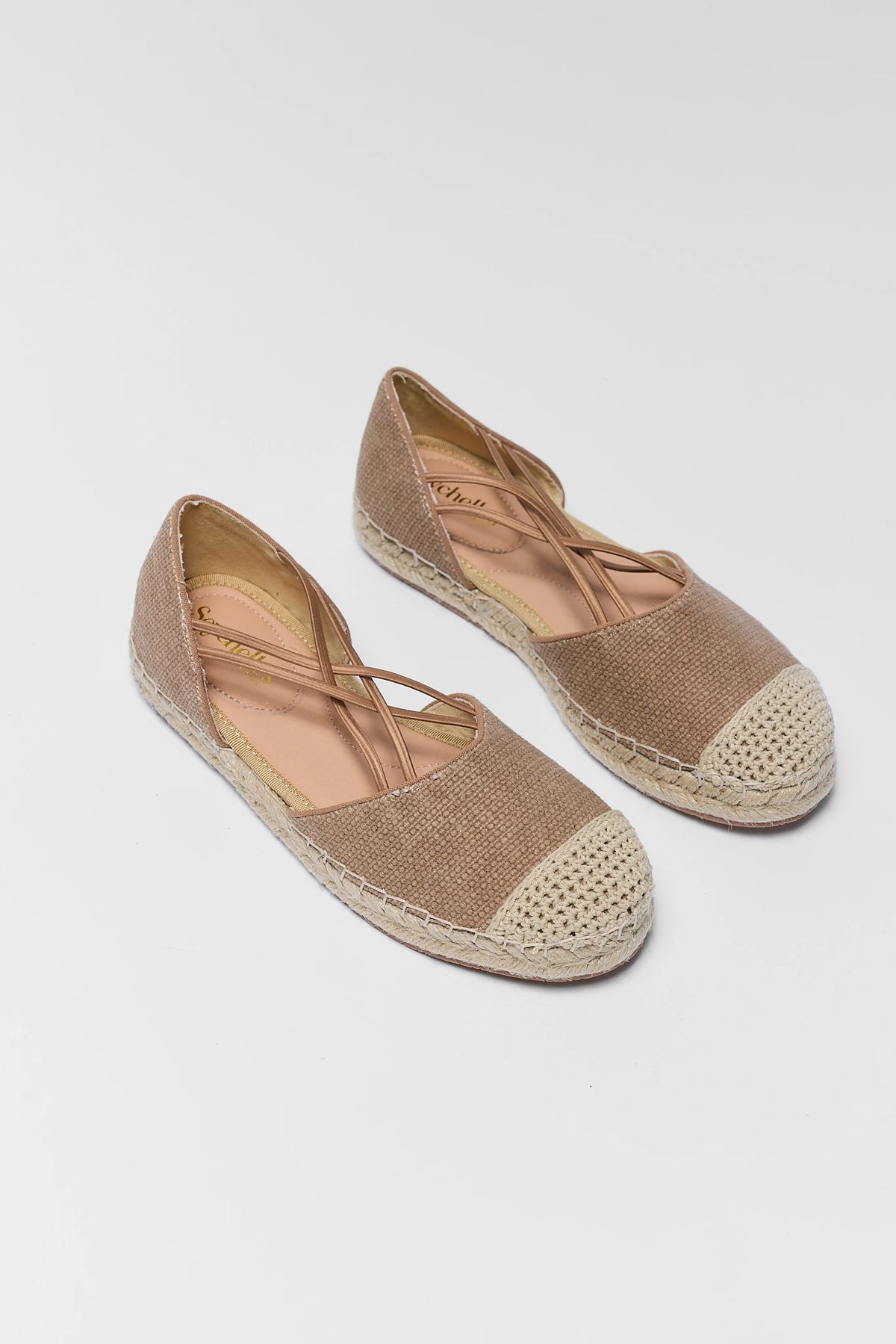 Pair of tan womens espadrilles with cross-strap lacing and crochet cap toe - Angled View | Avara