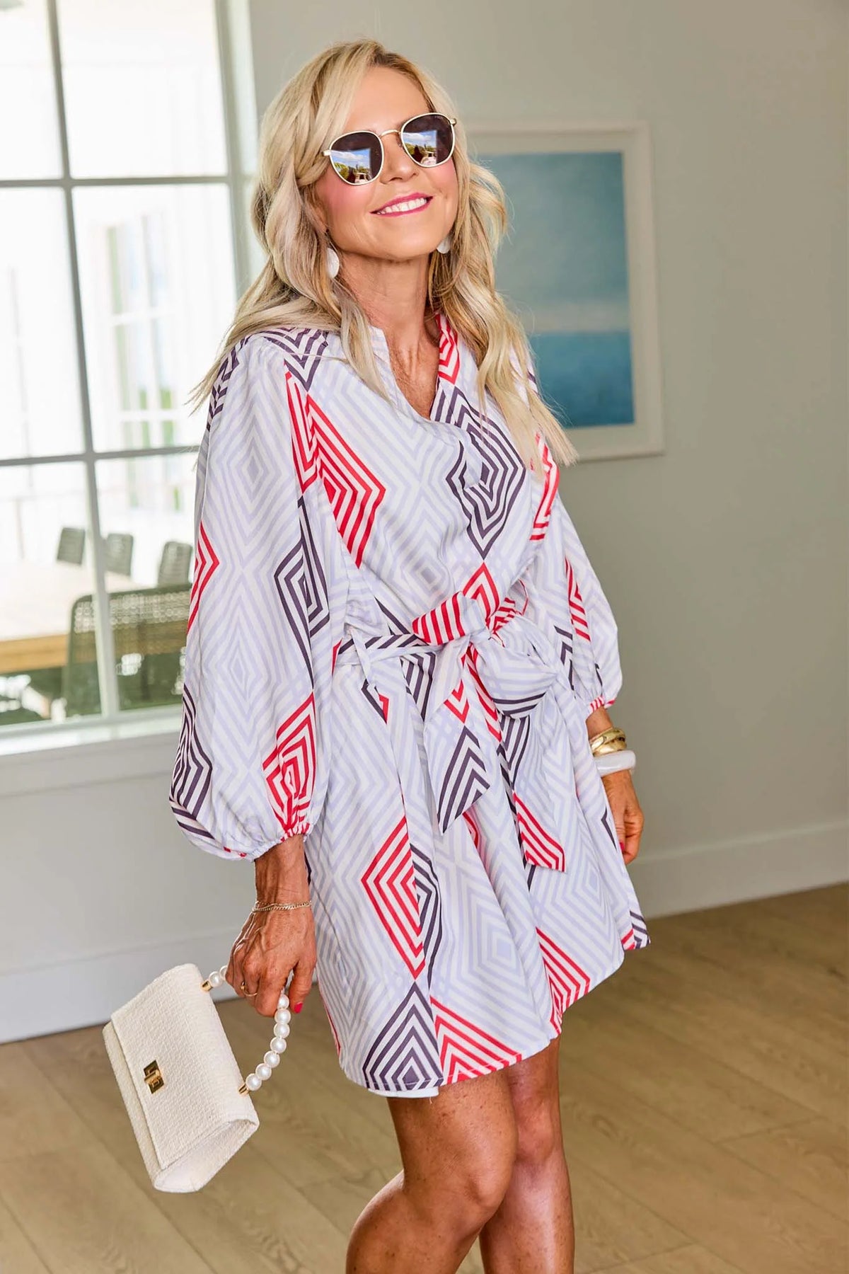 Woman wearing a patterned robe indoors with a neutral background