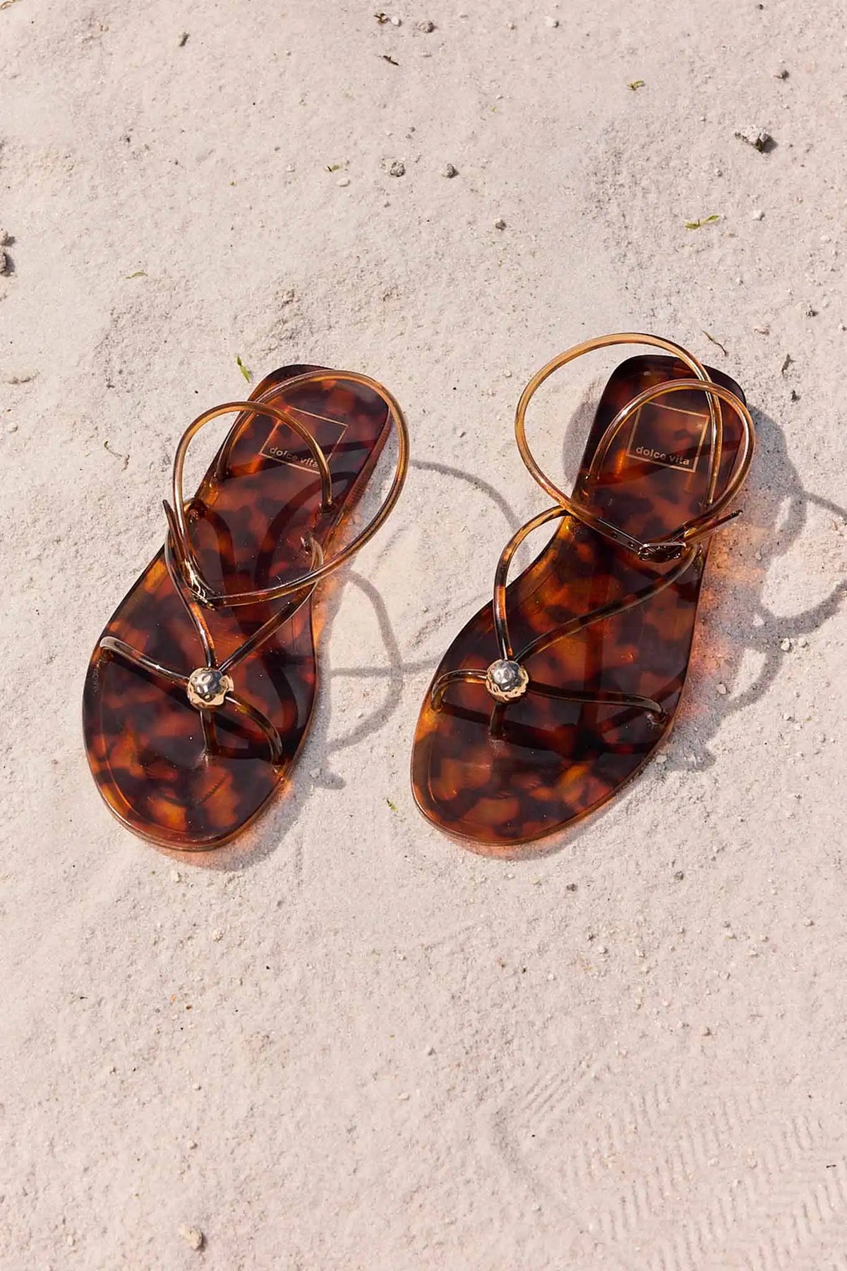 Tortoiseshell sandals with gold detail on sandy beach - Lifestyle Overhead Shot | Avara