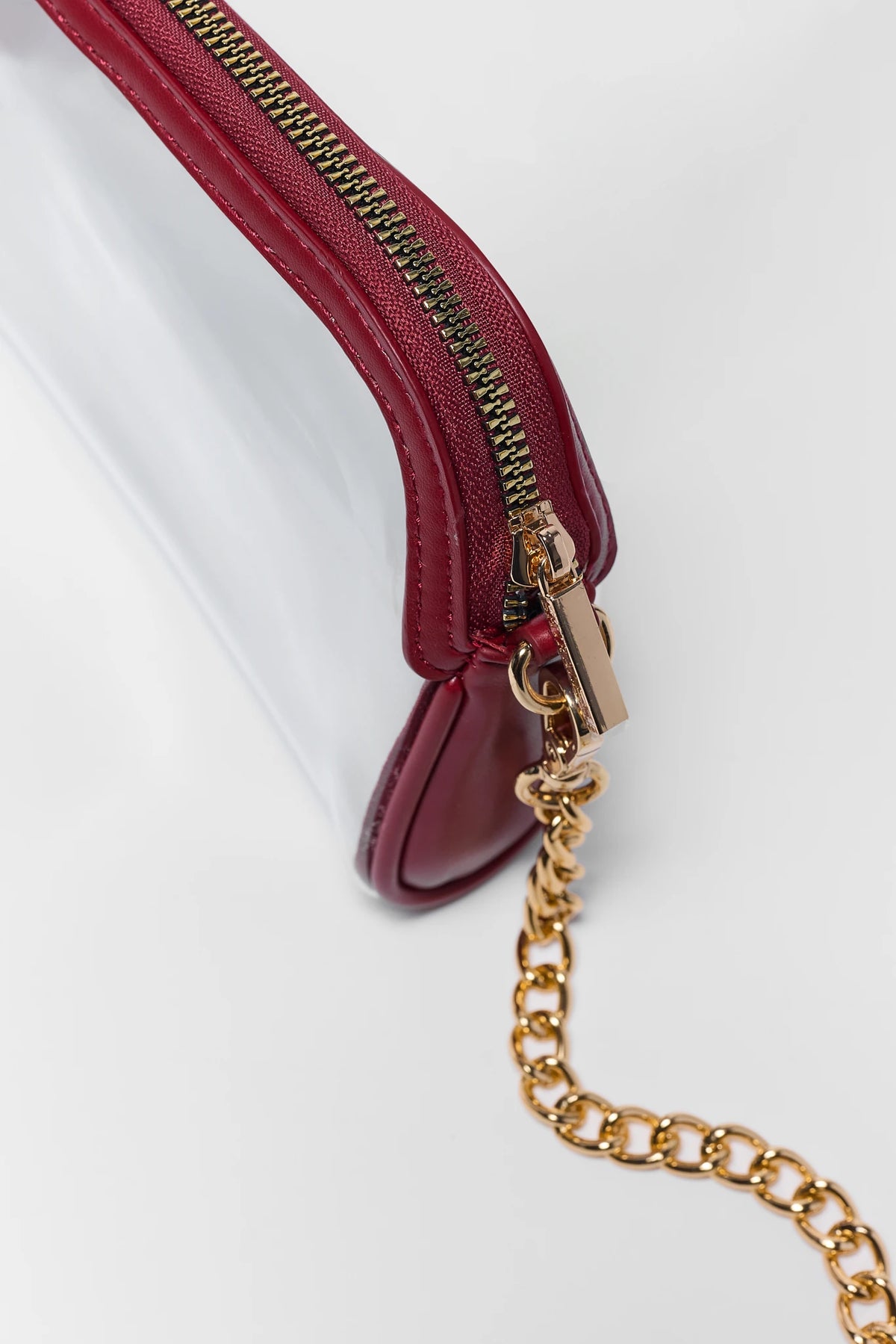 Maroon clear crossbody bag gold zipper and chain strap hardware close-up detail | Avara