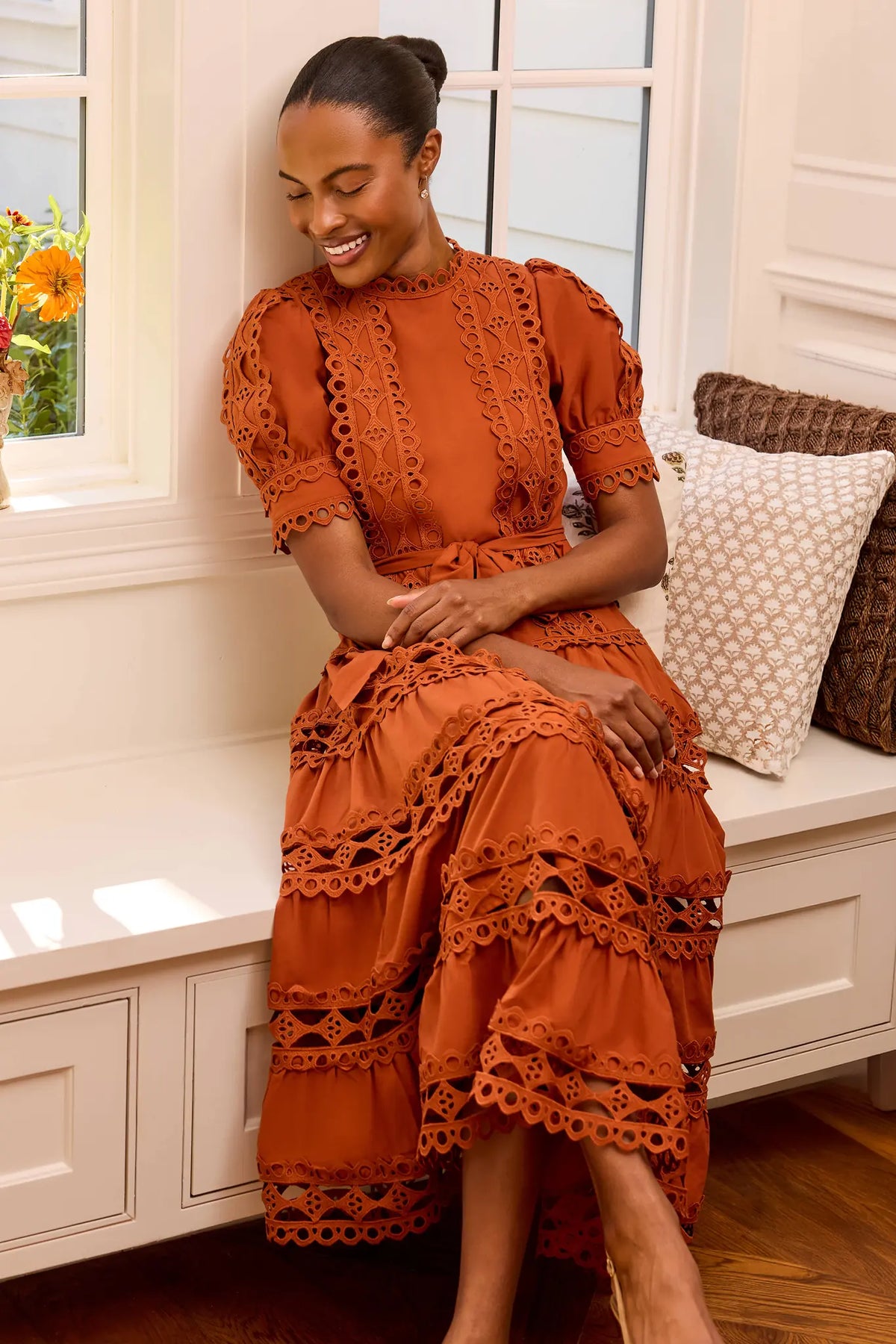 Rust Modest Midi Dress with Eyelet Trim - Seated Lifestyle View | Avara
