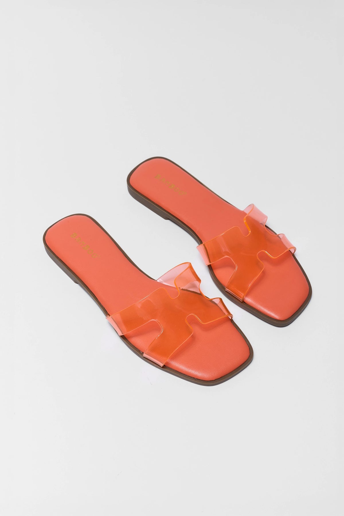 Orange jelly slip-on sandals with clear H-strap, square toe, flat lay pair - Front Angle | Avara