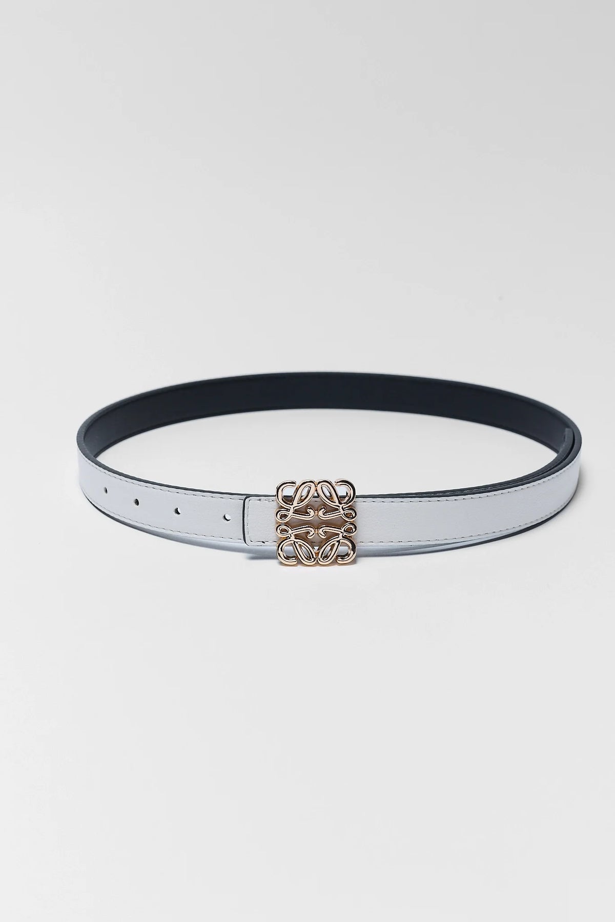 Rowan White Faux Leather Belt laid flat, slim silhouette with gold-tone monogram buckle | Avara
