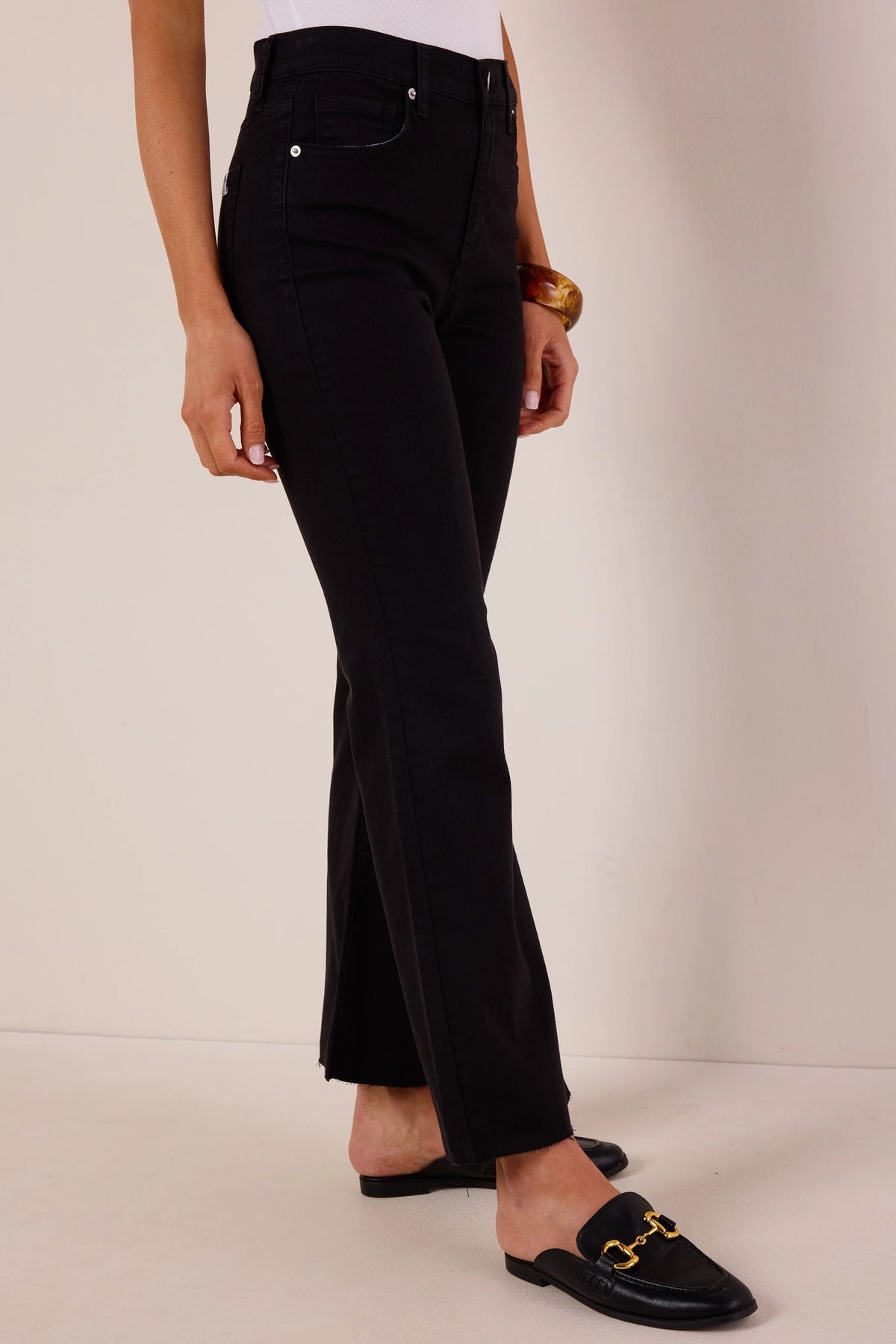 Heather Black Kick Flare Jeans with raw-edge hem and high waist, side profile view with amber bangle | Avara