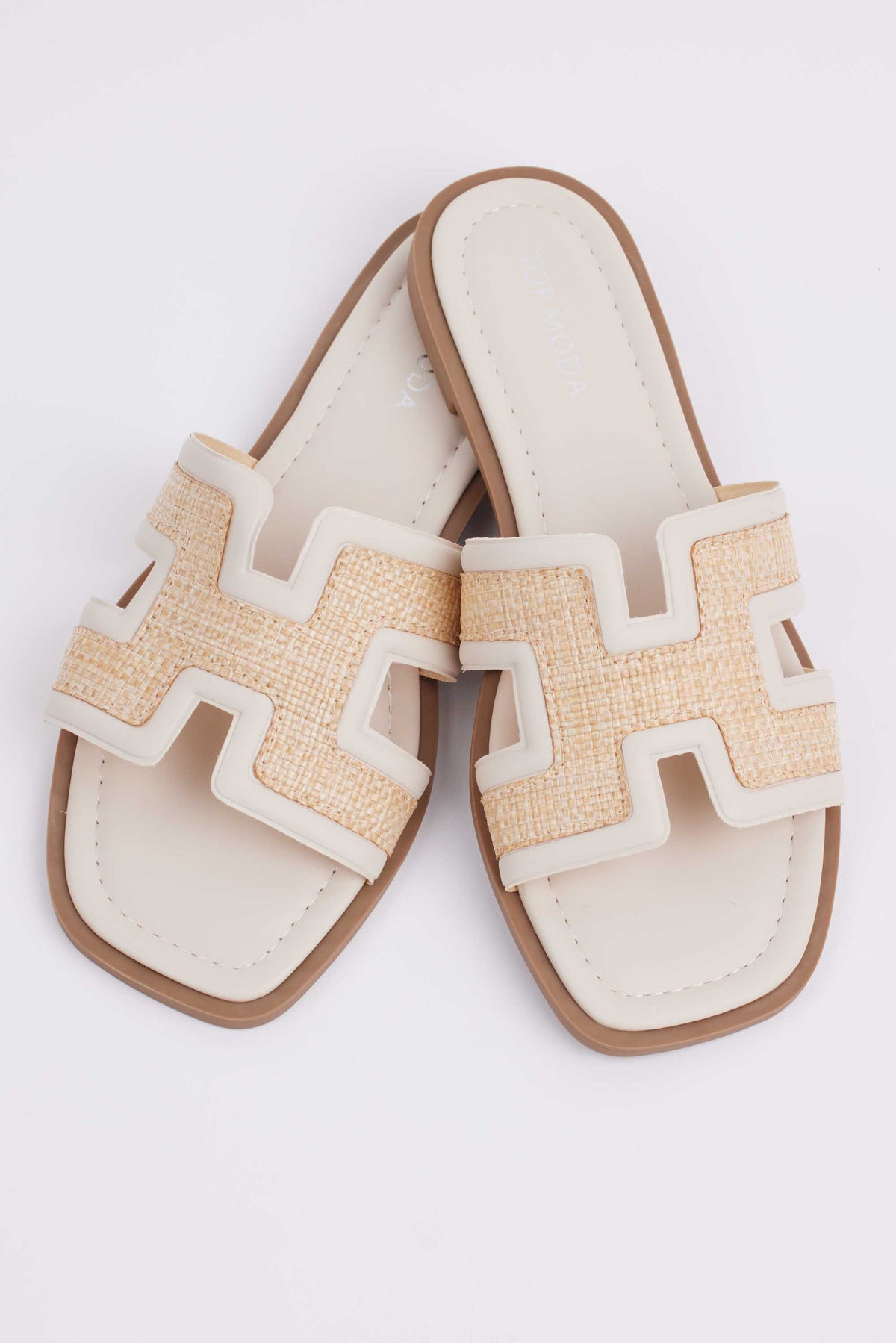 Cream women's raffia sandals flat lay showing woven strap texture and cushioned footbed | Avara