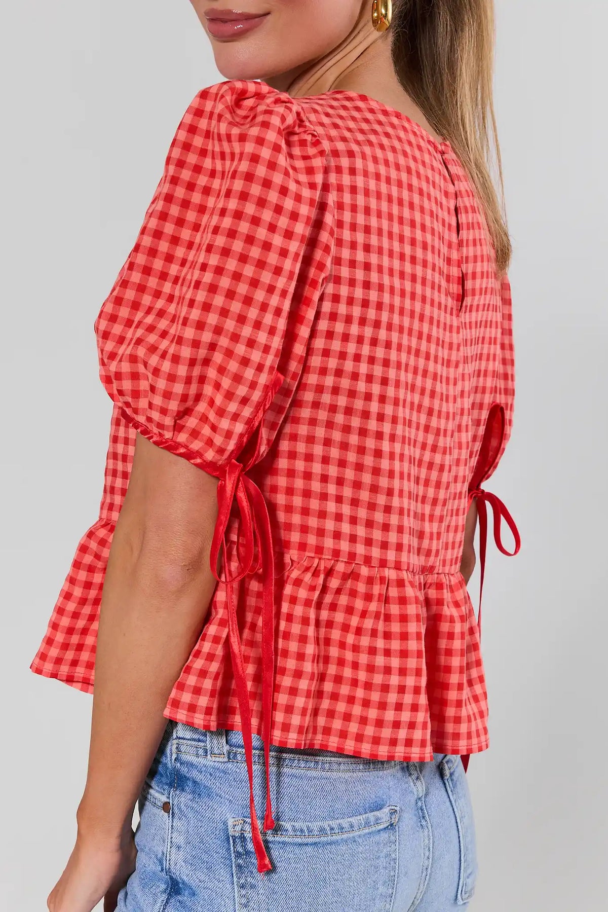 Felicia Red Gingham Peplum Top side view showing ribbon tie cuffs and peplum silhouette | Avara