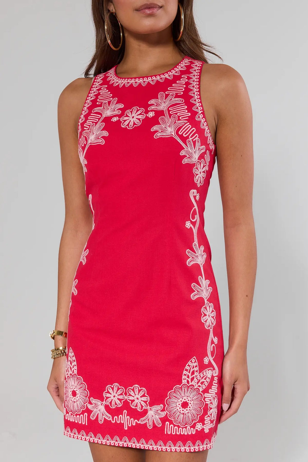 close up Red dress with white floral embroidery on a gray background