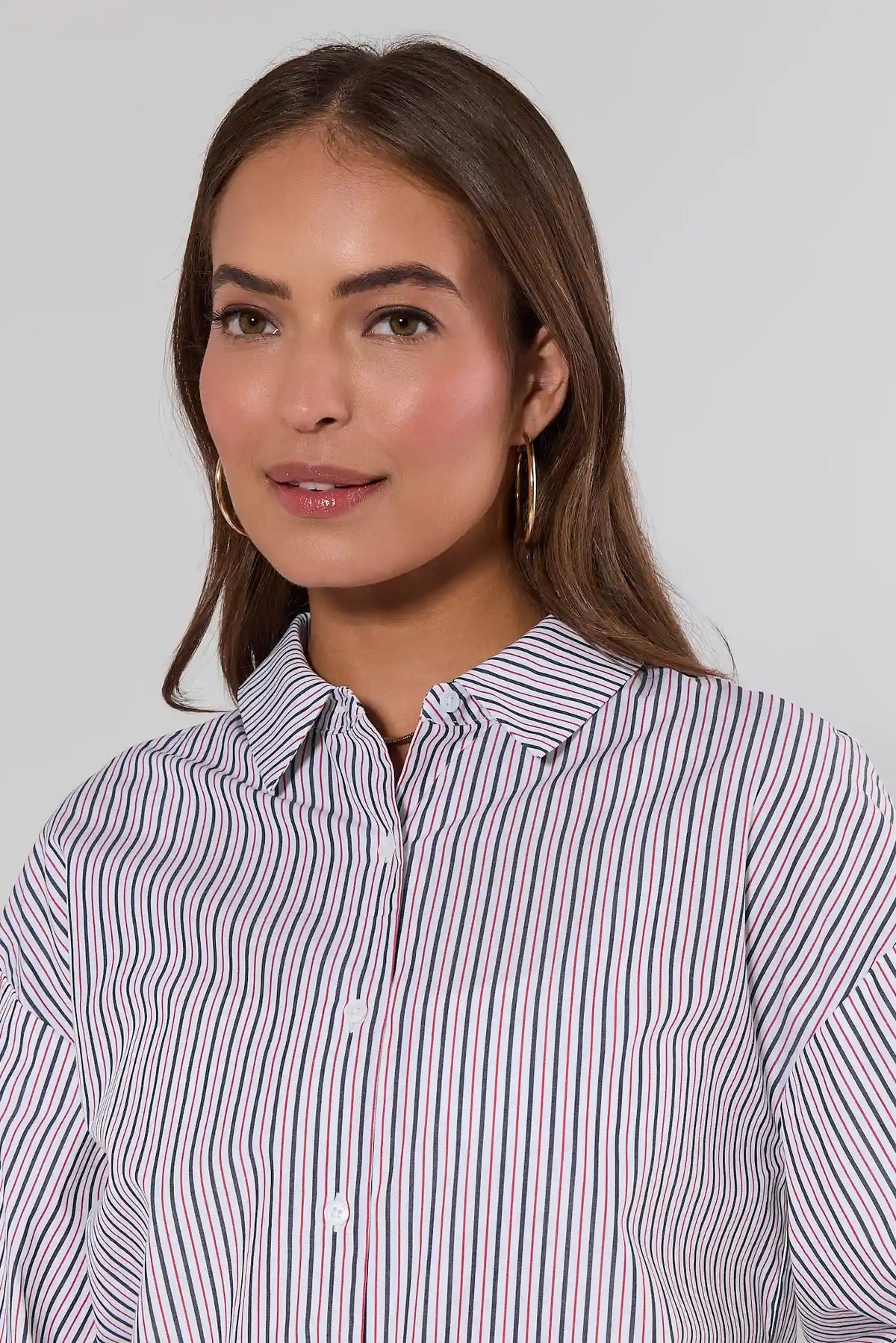 close up Woman wearing a striped shirt against a plain background
