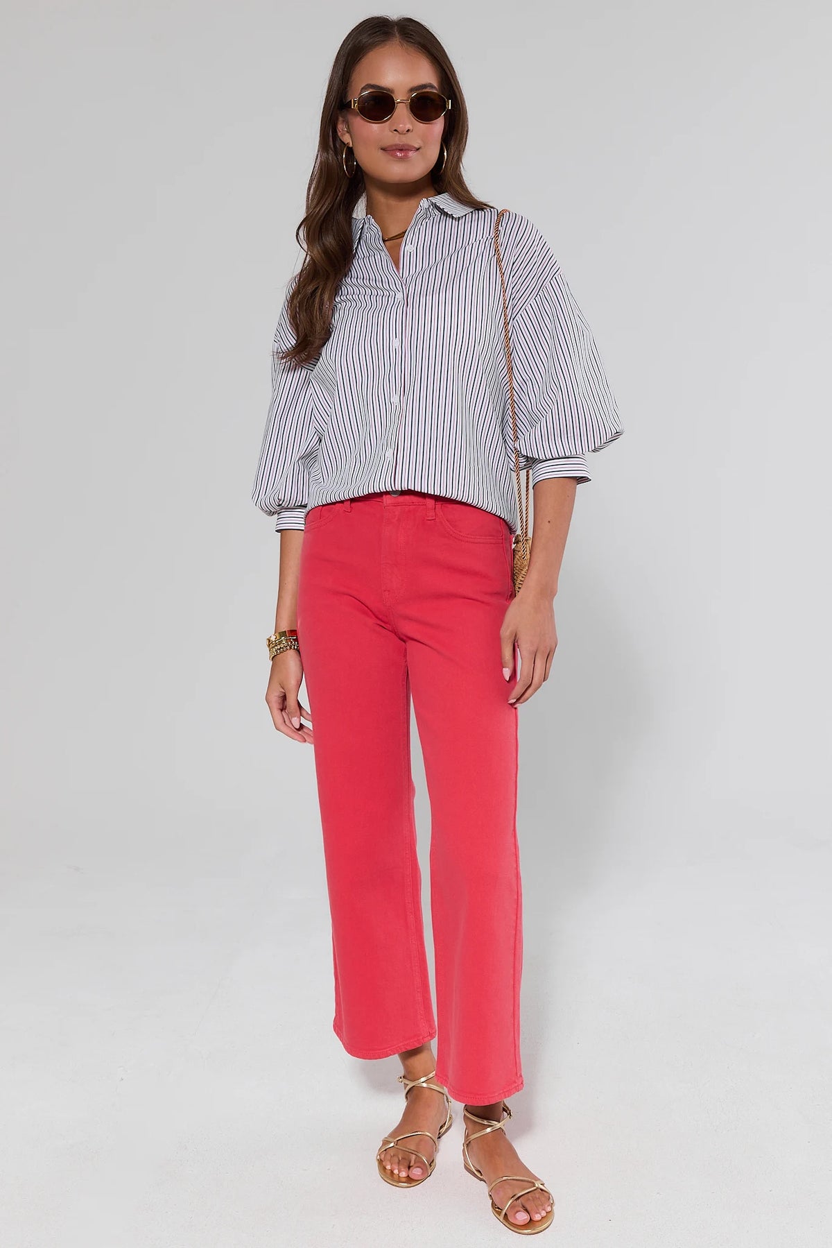 Woman wearing a striped shirt and red pants on a white background