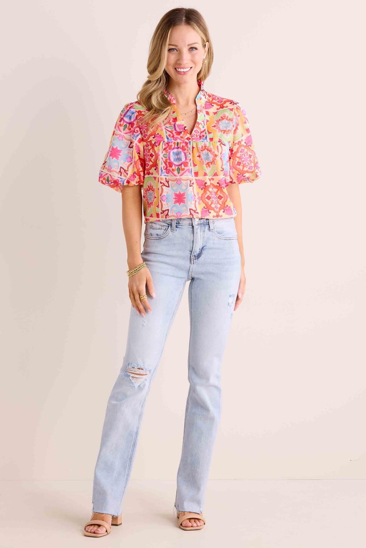 Phoebe Jeans light-wash high-rise kick-flare styled with colorful print blouse and nude sandals | Avara