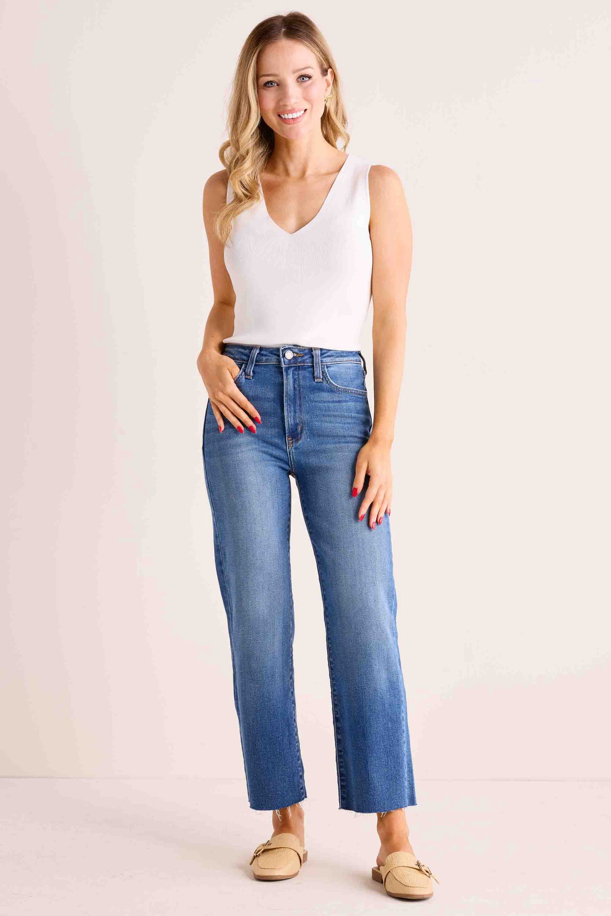 Melanie Medium Wash Straight Leg Jeans, high-rise with raw hem, side profile showing straight-leg silhouette and tan mule loafers | Avara