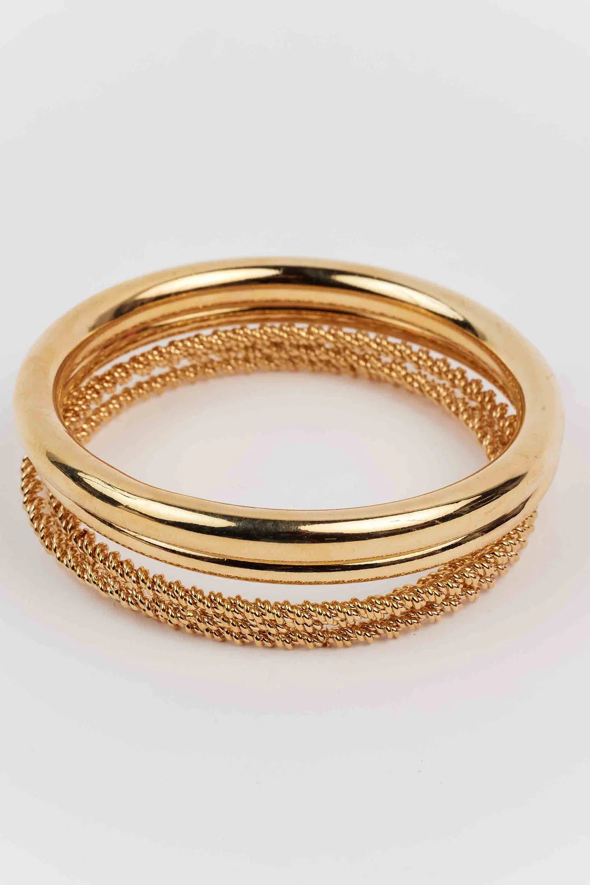 Sandra Gold Bangle Set featuring a smooth bangle and a twisted-rope style bangle, showcasing a shiny gold-tone design. Perfect for enhancing any outfit.