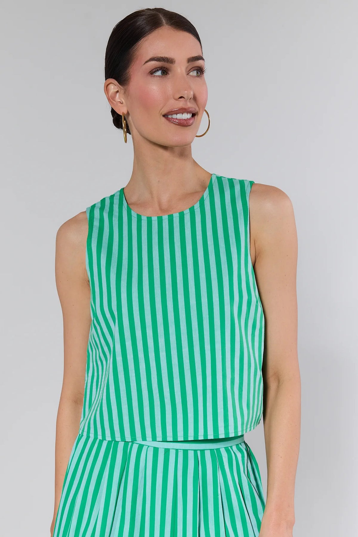 Woman wearing a green striped tank top with matching skirt, front close-up view | Avara