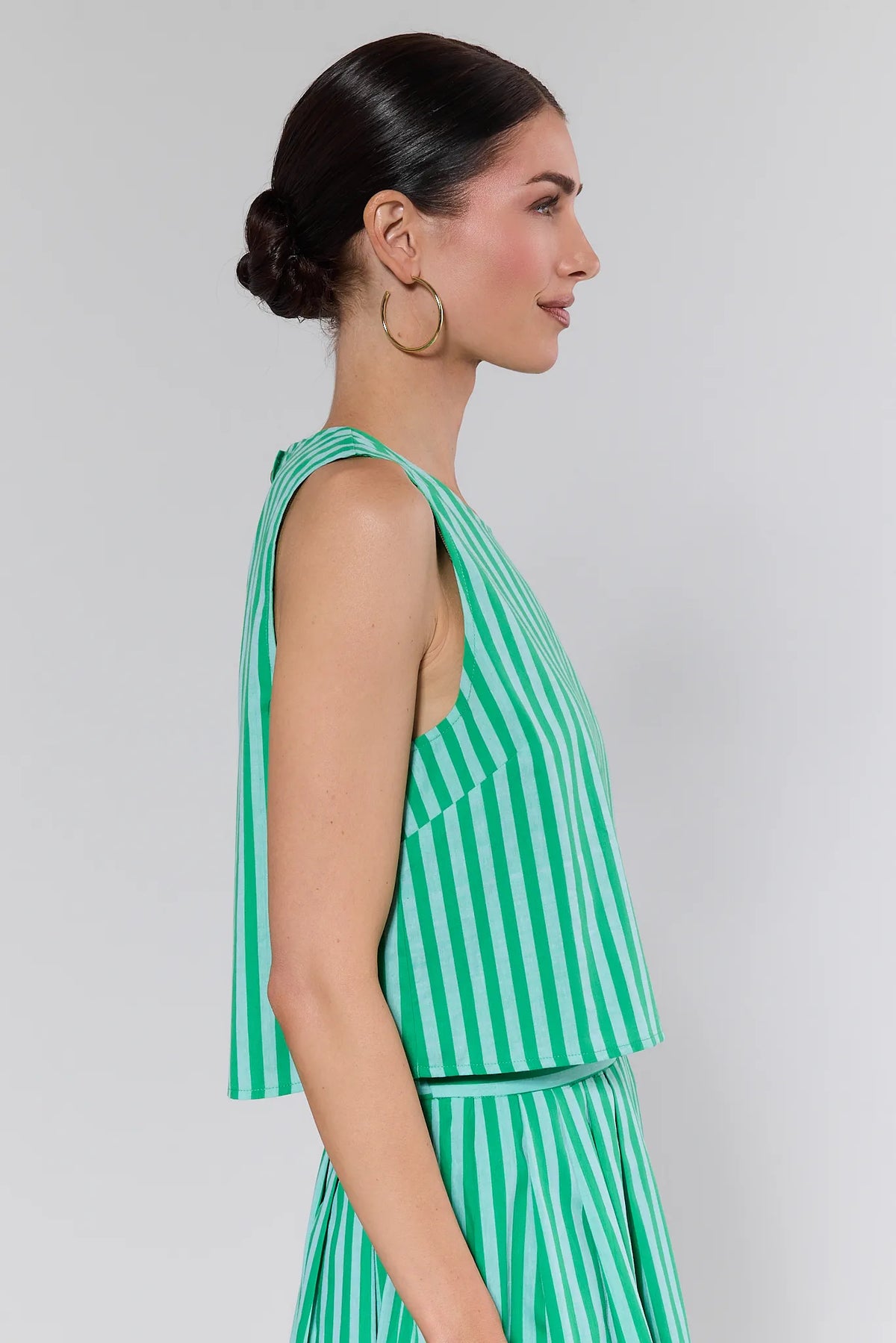 Green striped boxy tank top with wide straps, side profile view on model with matching skirt | Avara