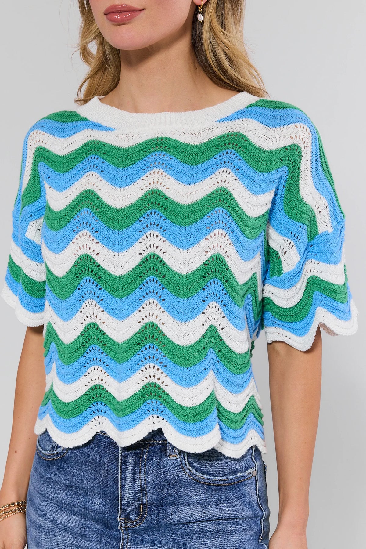 Woman wearing a colorful striped sweater against a plain background