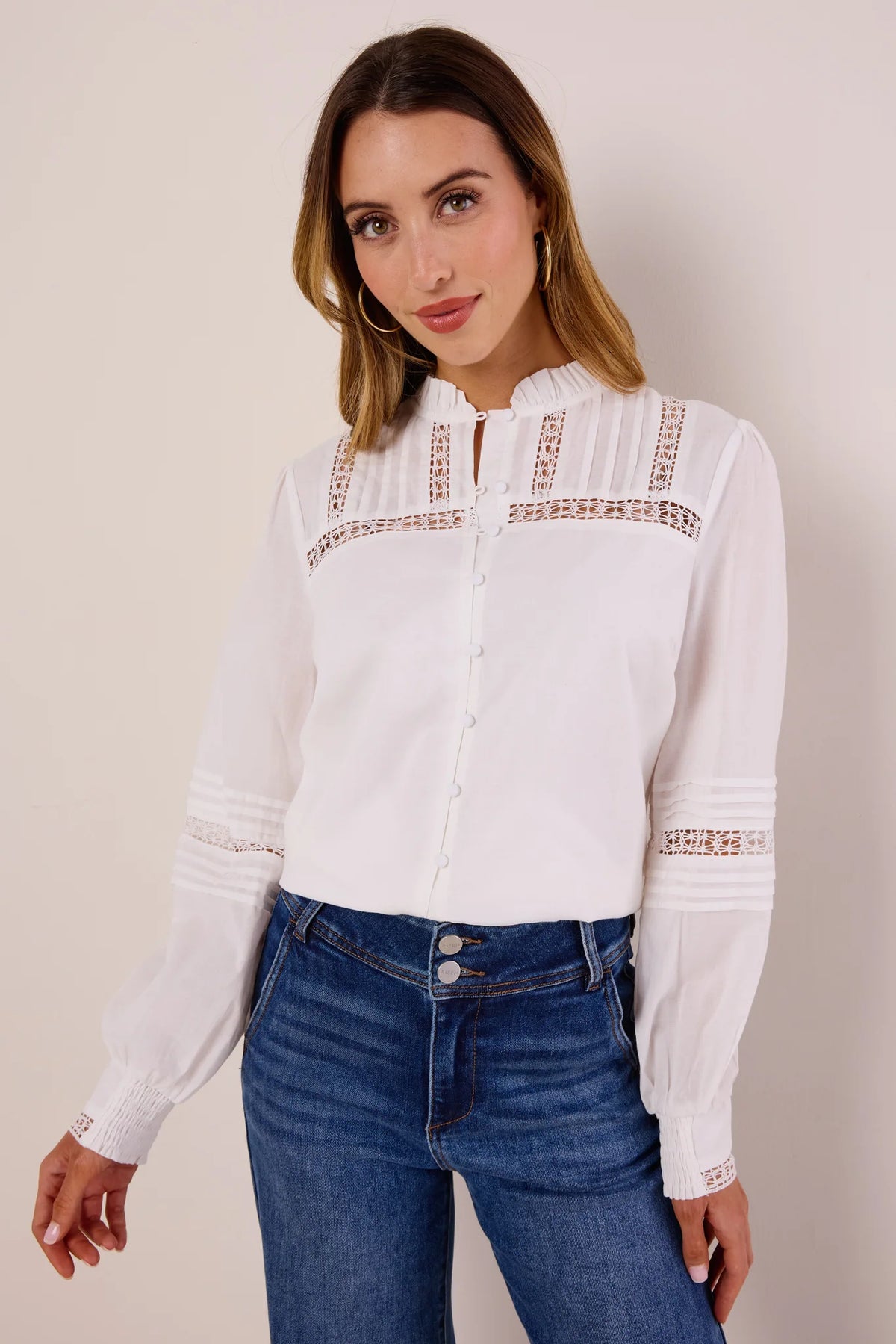 Sable White Button Up Top with lace-inset yoke, pintucks, ruffled collar, fabric-covered buttons, paired with dark wash jeans - Front View | Avara