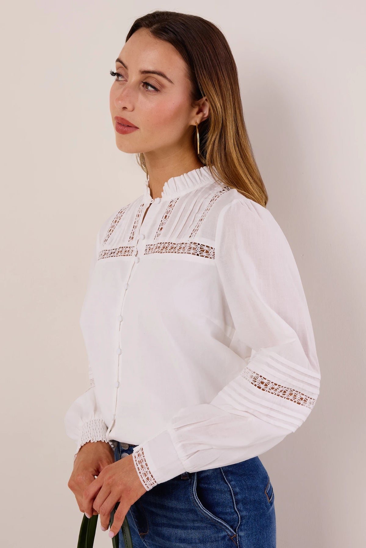 Sable White Button Up Top with lace insets and pintucks shown from side angle, paired with blue jeans and gold hoop earring | Avara