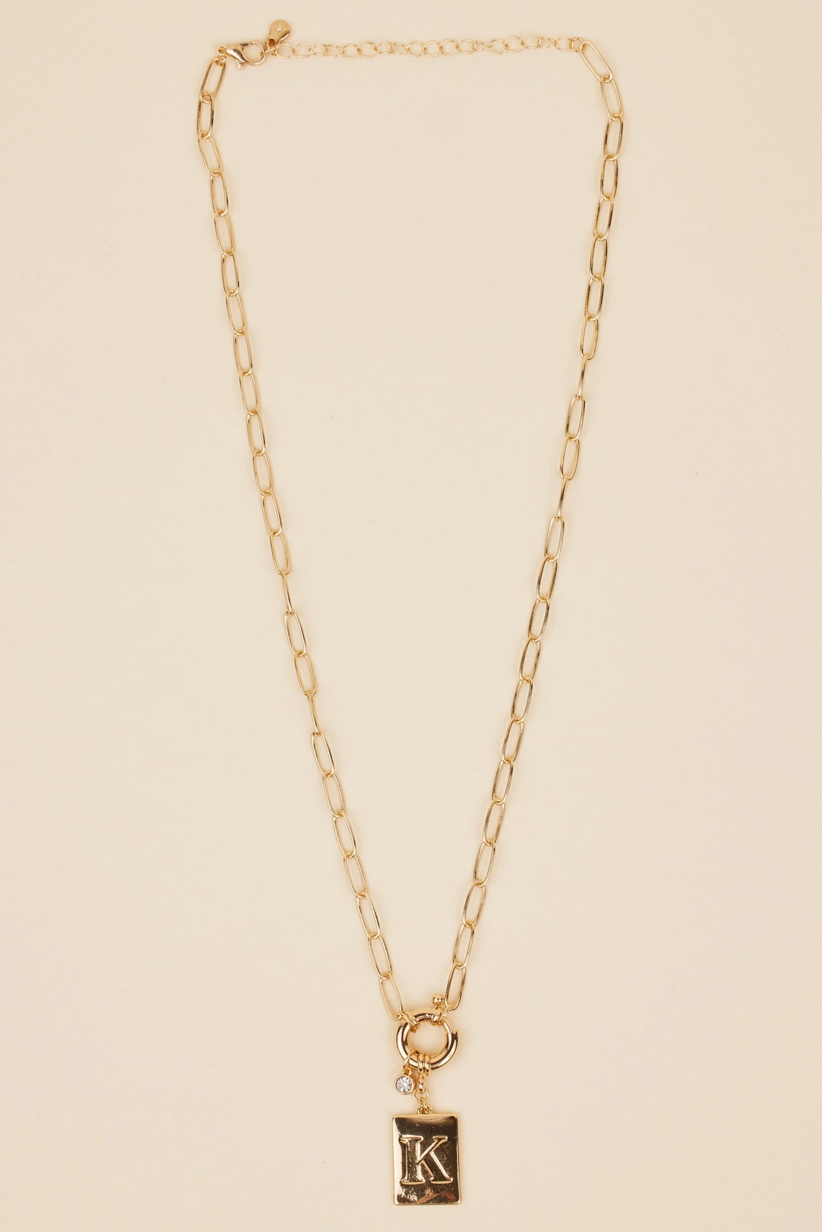 Gold Initial Charm Necklace full-length flat lay with K pendant, paper-clip chain, and lobster clasp extender | Avara