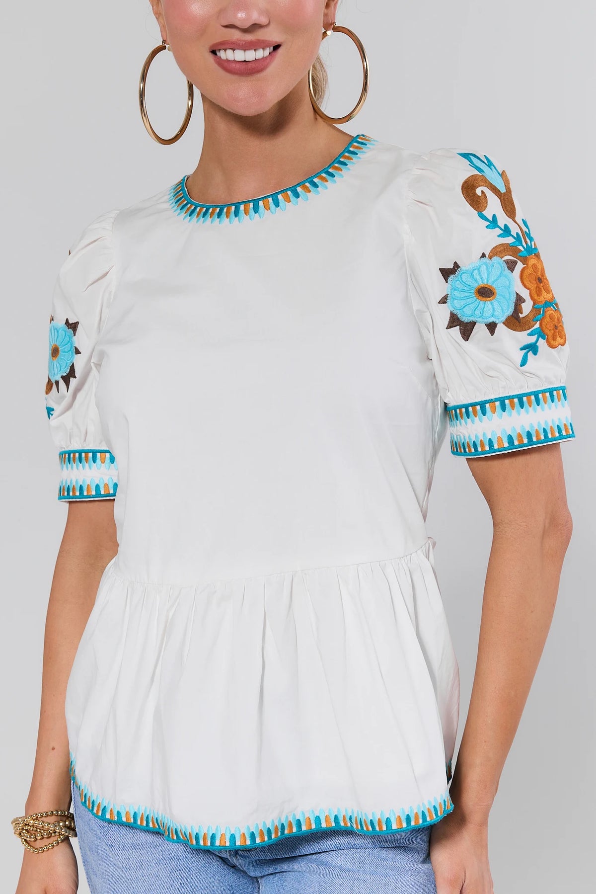 White Embroidered Peplum Top - Close-Up of Turquoise Floral Sleeve Detail | Avara