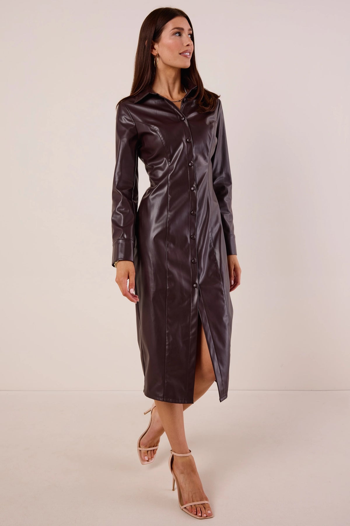 Rena Brown Faux Leather Midi Dress, button-front with front slit, paired with strappy heeled sandals - Side View | Avara