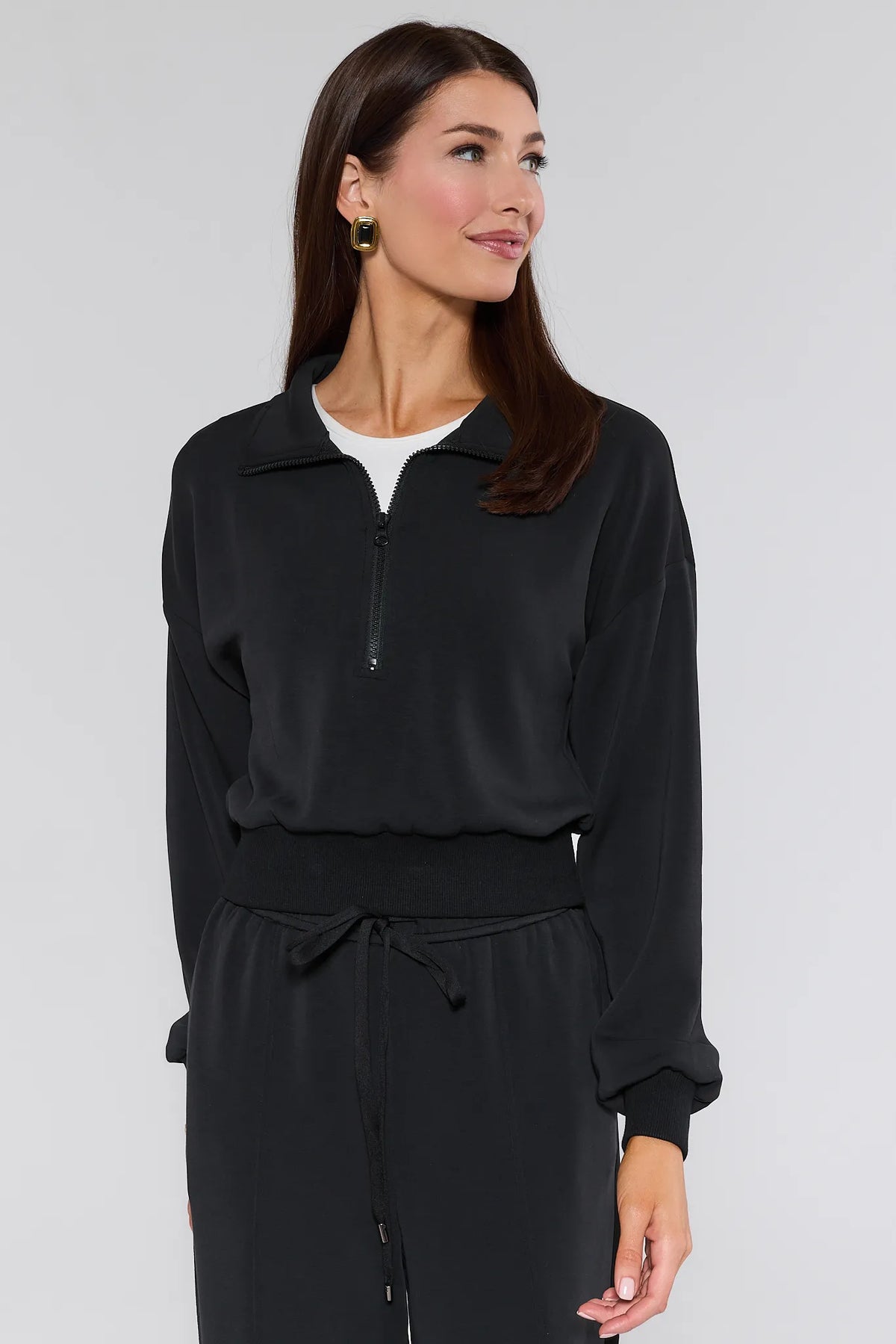 Lucy Black Half Zip Pullover, front close-up showing half-zip collar, ribbed waistband, paired with matching pants | Avara