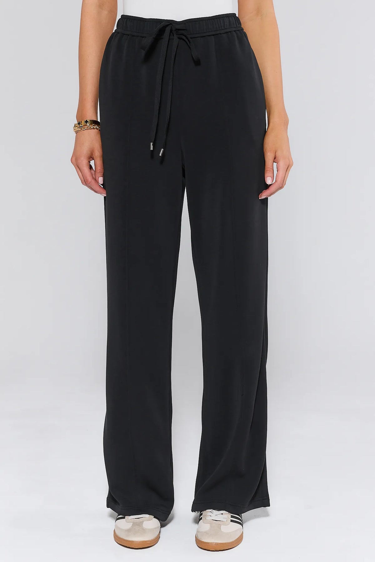 Lucy Black Wide Leg Lounge Pants with drawstring high-rise waist, front view on model with sneakers | Avara