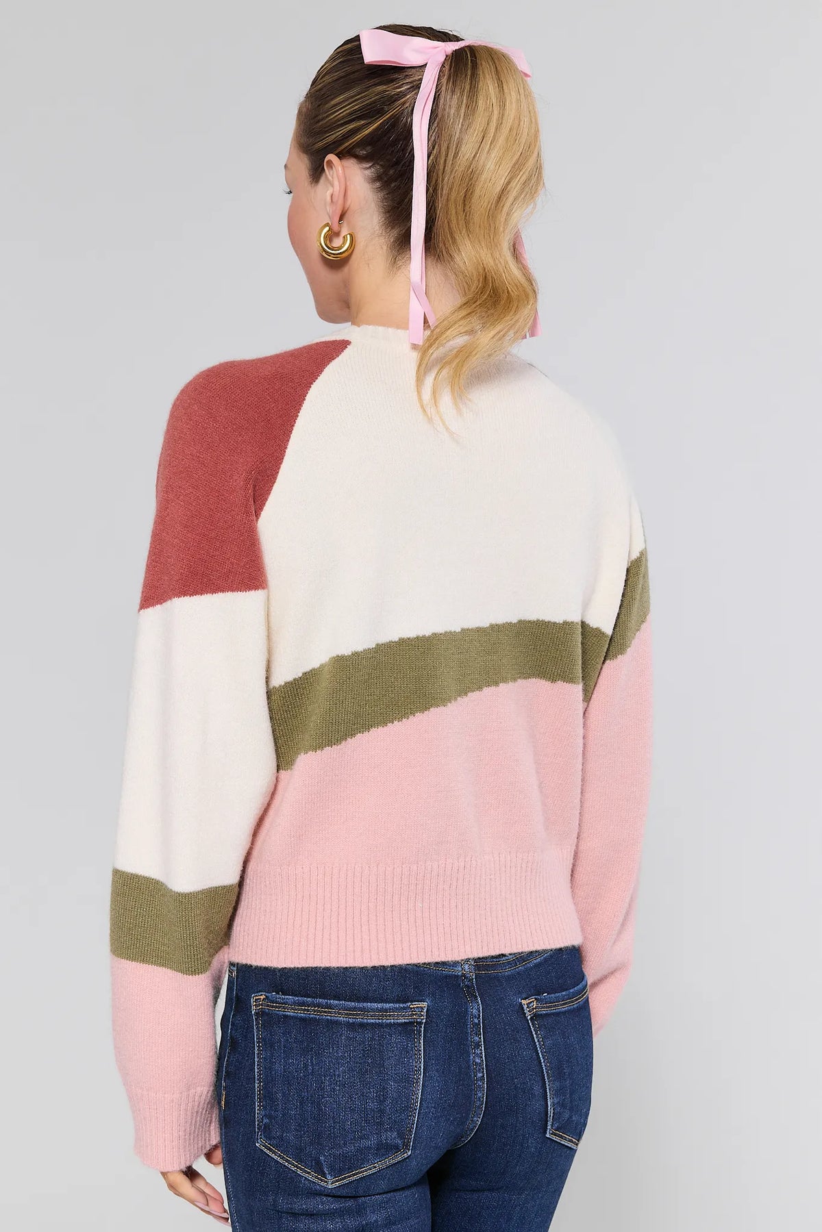 Woman wearing abstract knit Beverly Sweater in pink, cream & olive with jeans - Back View | Avara