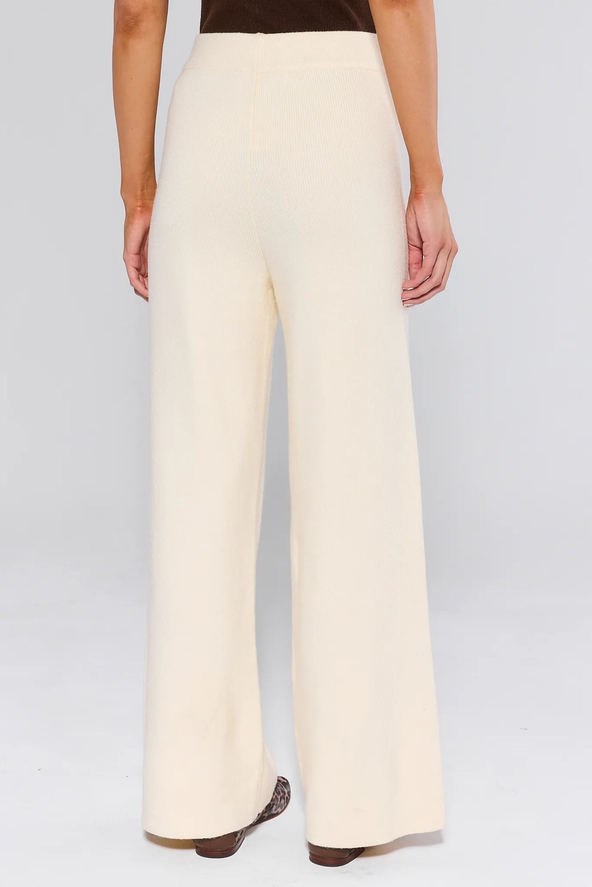 Elle Ivory Knit Pants showing high-waisted wide-leg back silhouette, ribbed knit texture, paired with leopard flats — Back View | Avara