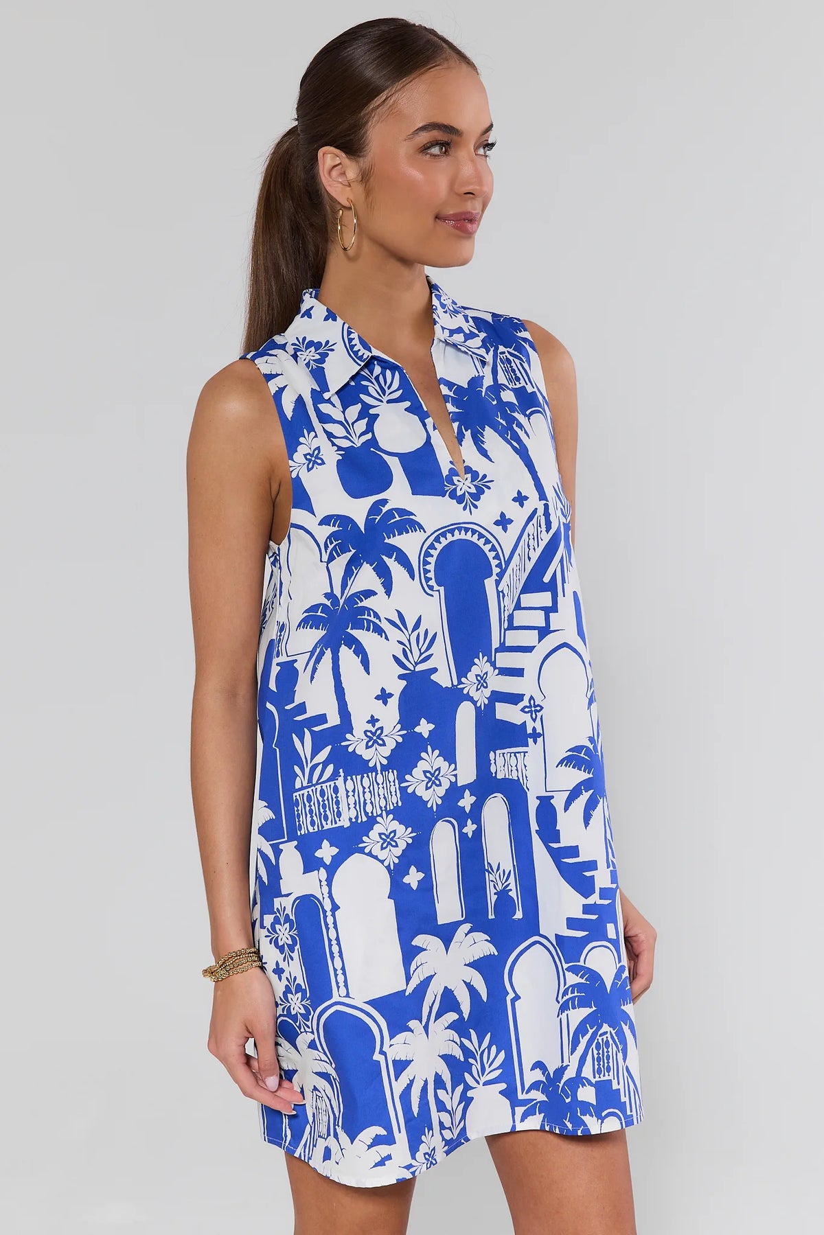 Blue and white Moroccan print sleeveless shift dress, side angle view showing shift silhouette | Avara