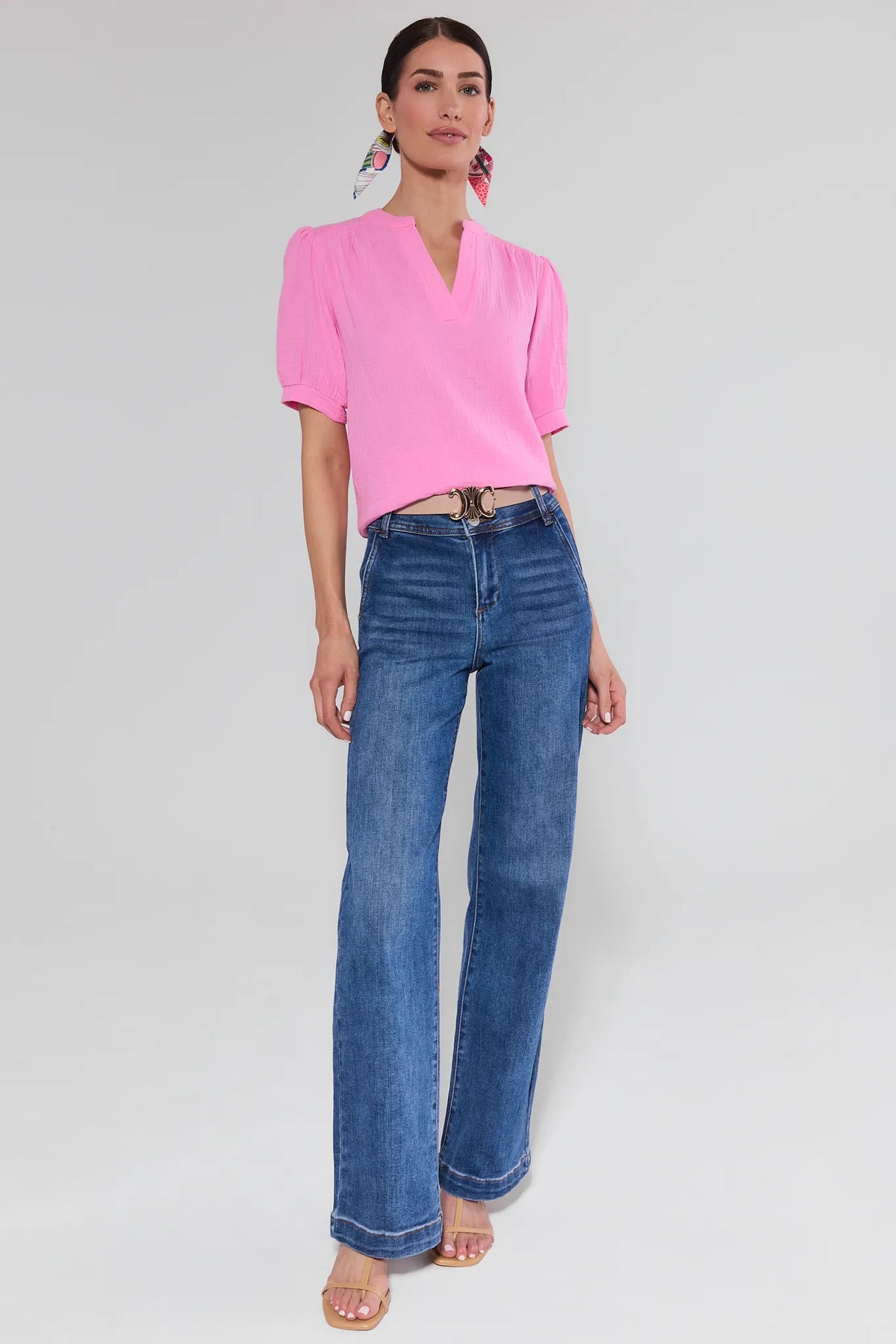 View 3: Woman wearing a pink blouse and blue jeans on a white background