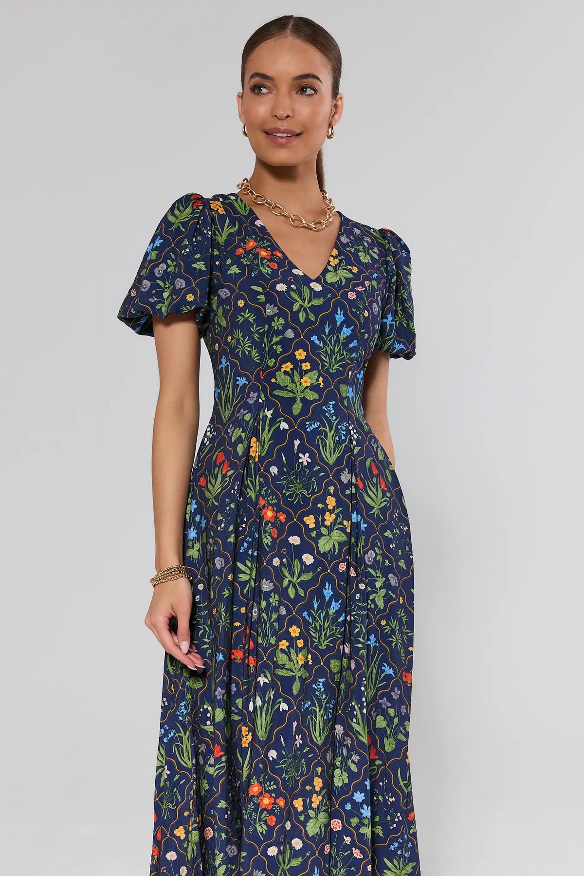 Navy floral print midi dress with puff sleeves and V-neckline, front 3/4 view on model | Avara