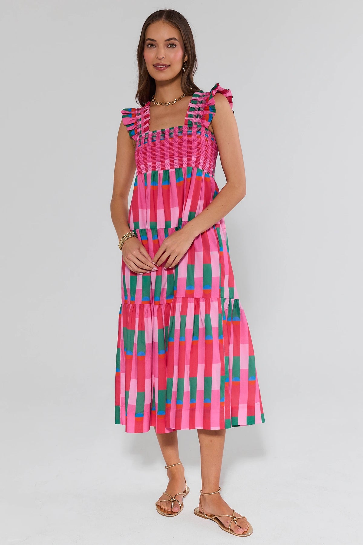 Woman wearing a colorful dress with a geometric pattern on a white background