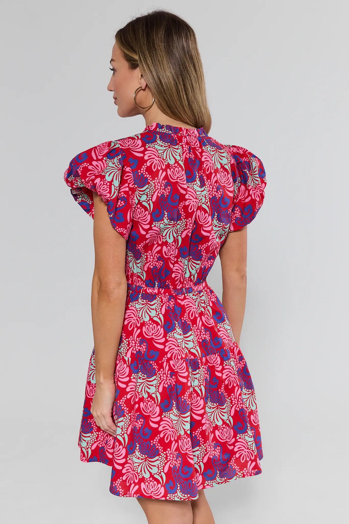 Woman wearing a red floral dress on a white background