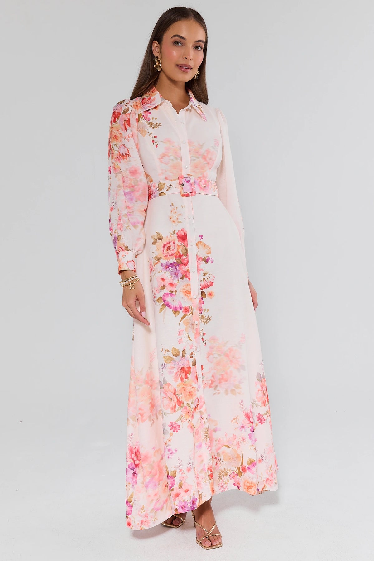 Woman wearing a long floral dress on a white background