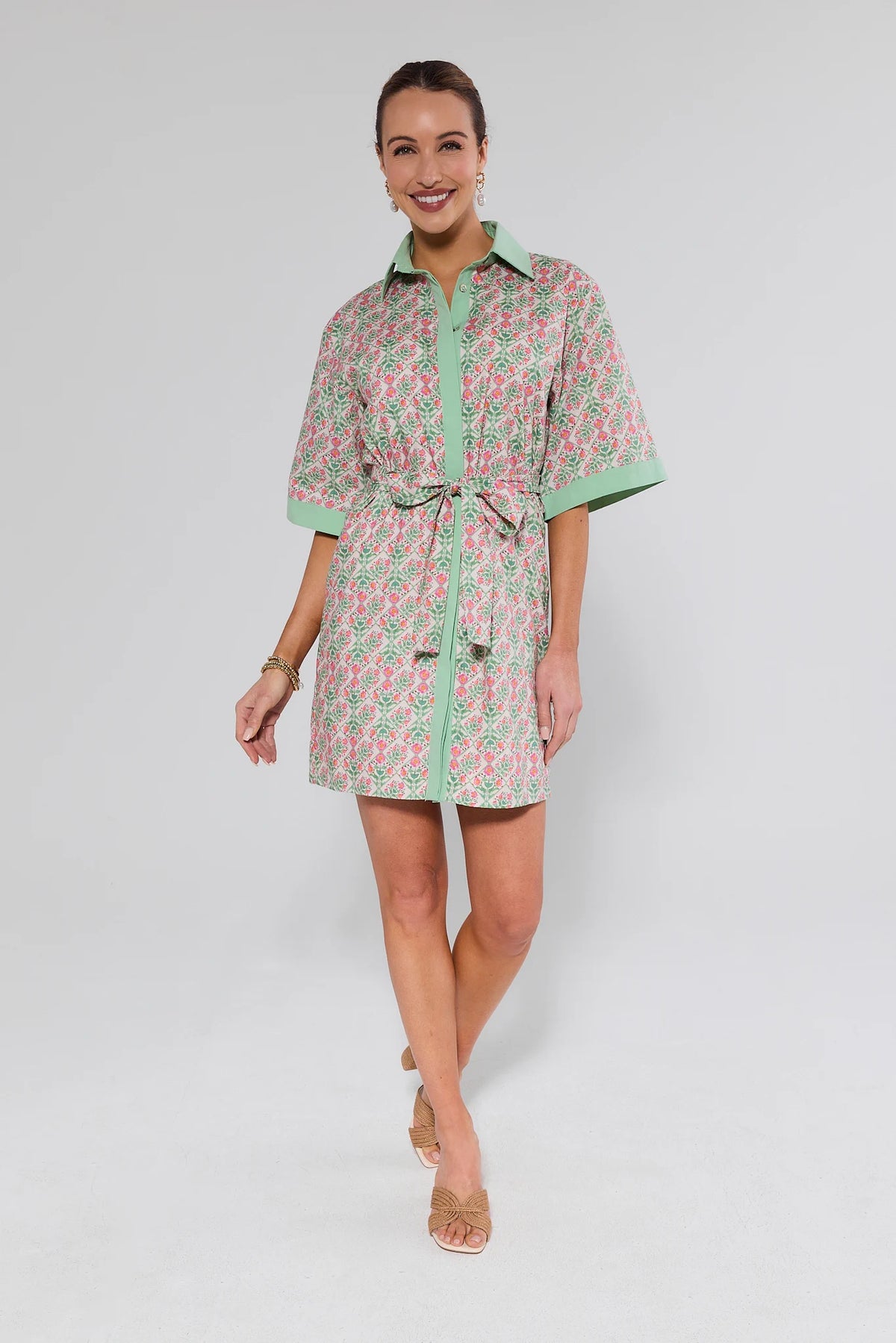 Woman wearing a patterned dress on a plain background