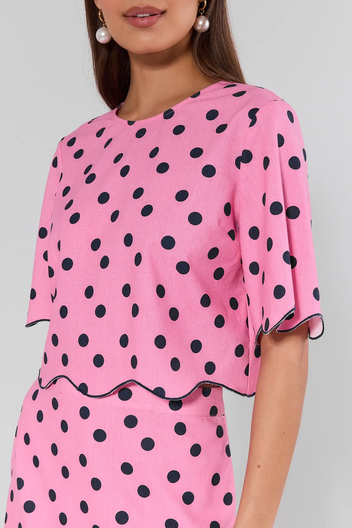 Maryl Pink Polka Dot Top - Side Detail Close-Up, flutter sleeve and navy scalloped trim on pink and navy print | Avara