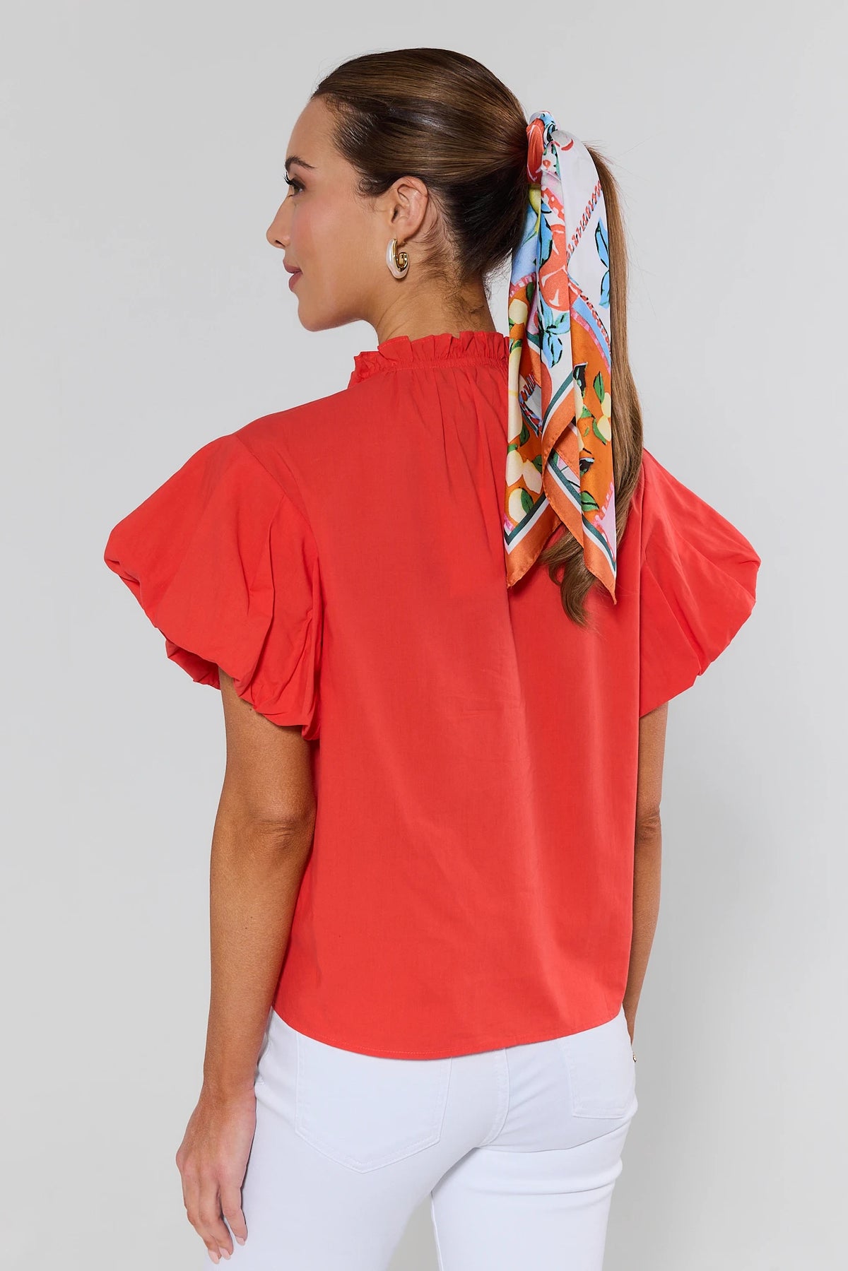 Agnes Orange Split Neck Top with flutter sleeves and ruffle neckline - Back View styled with white pants | Avara