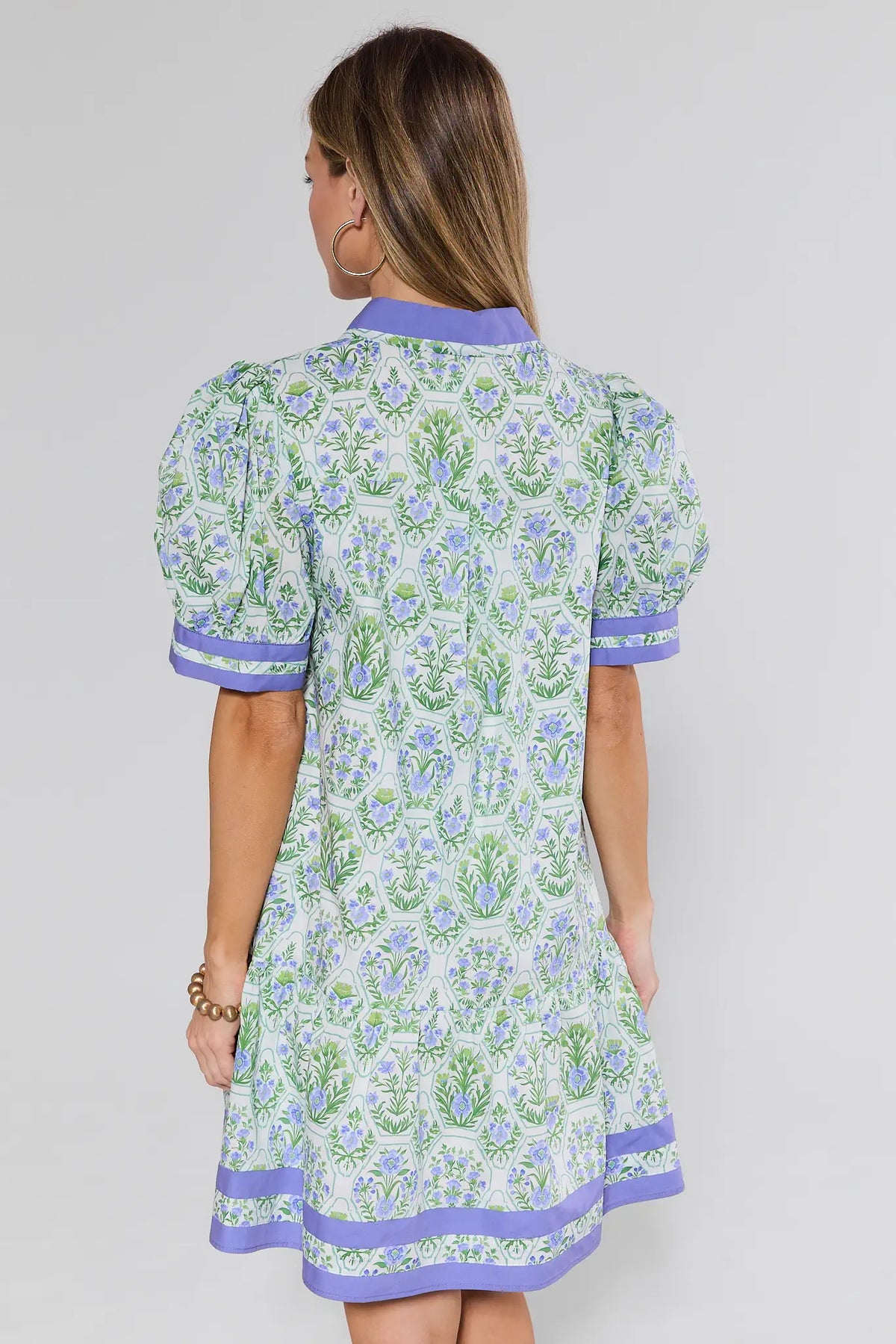 Woman wearing a floral dress with a plain background