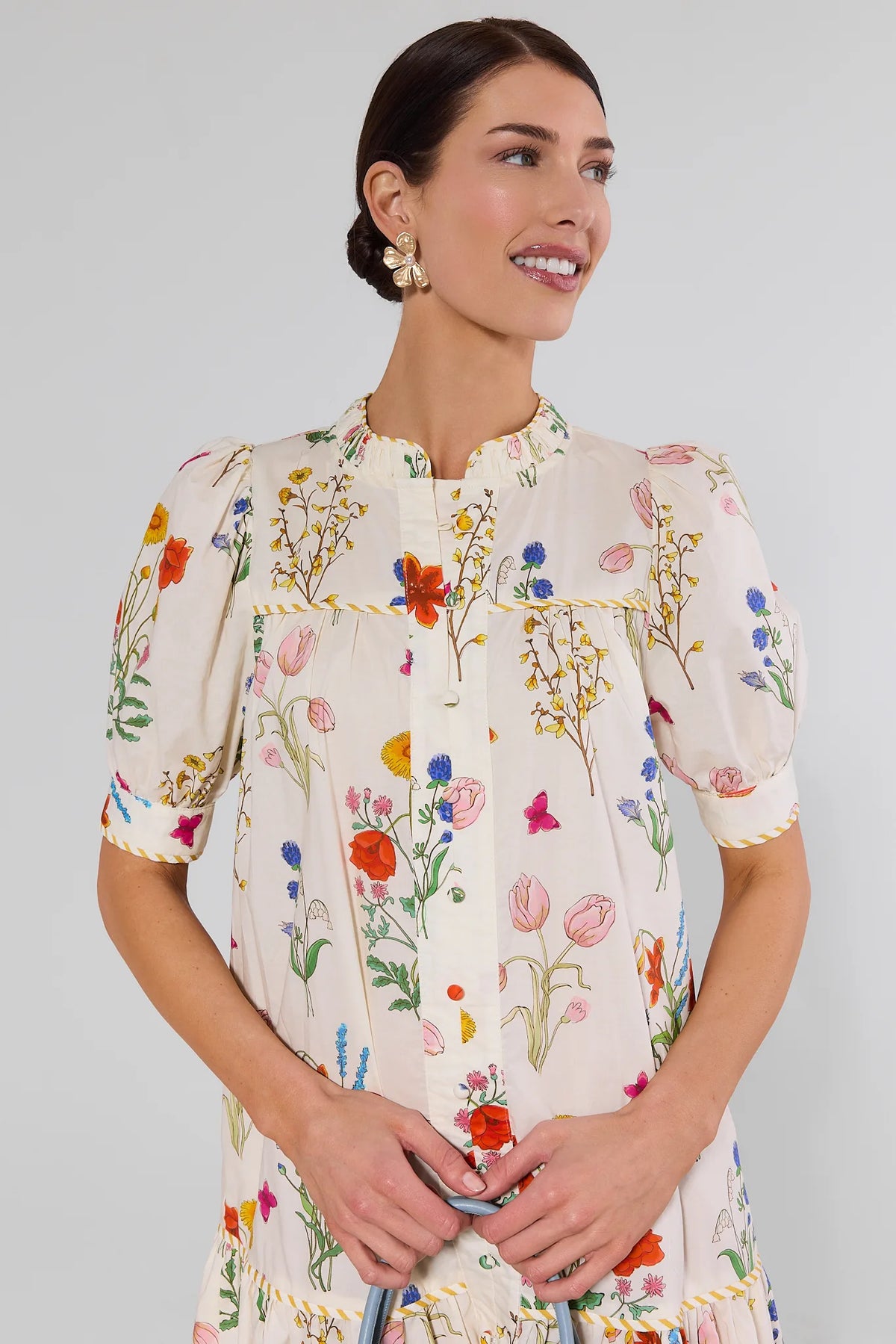 Close-up of white floral drop waist dress showing ruffled neckline and botanical print detail | Avara