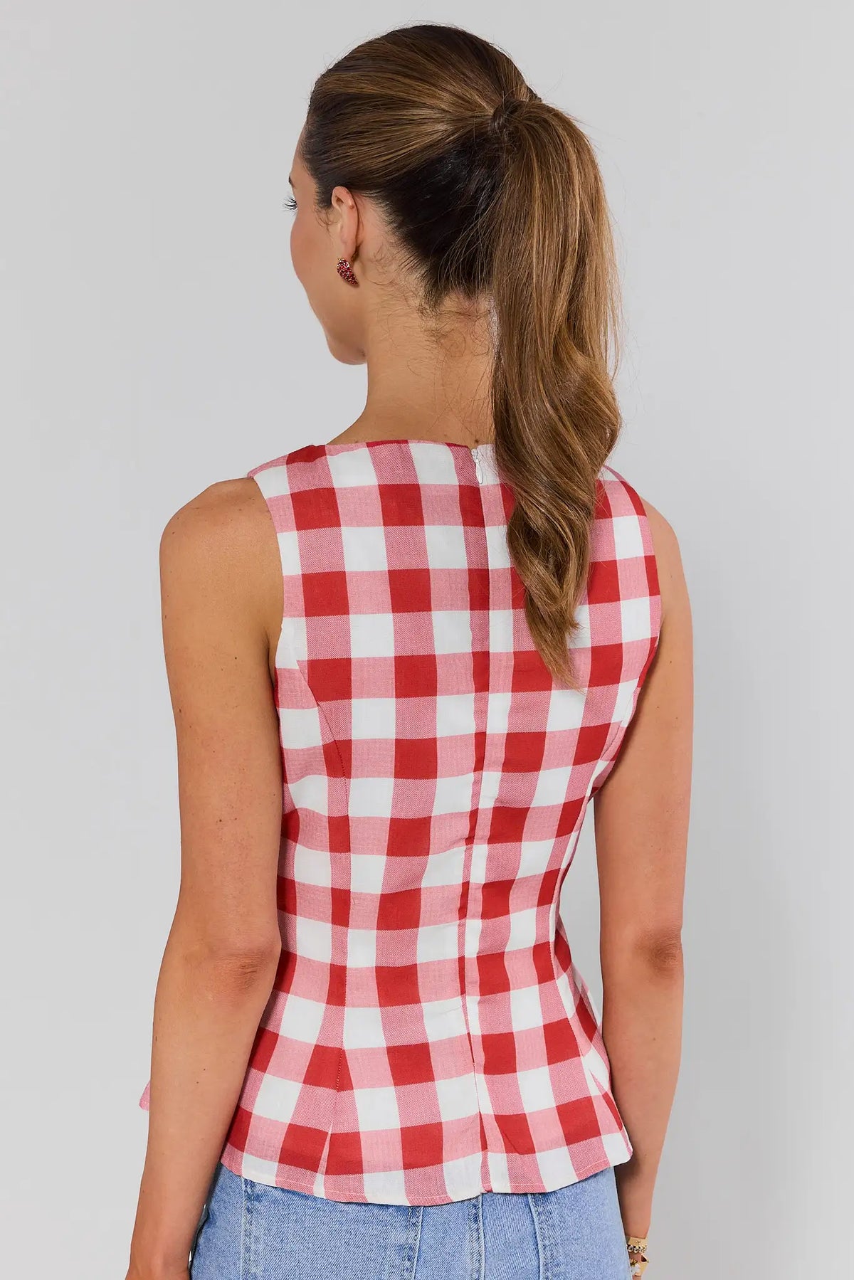 Back view of women's red gingham sleeveless peplum top with zip closure | Avara
