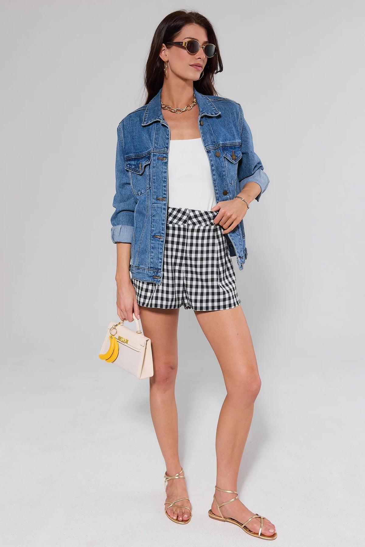Women's black gingham shorts styled with denim jacket and gold sandals, full-length styled look | Avara