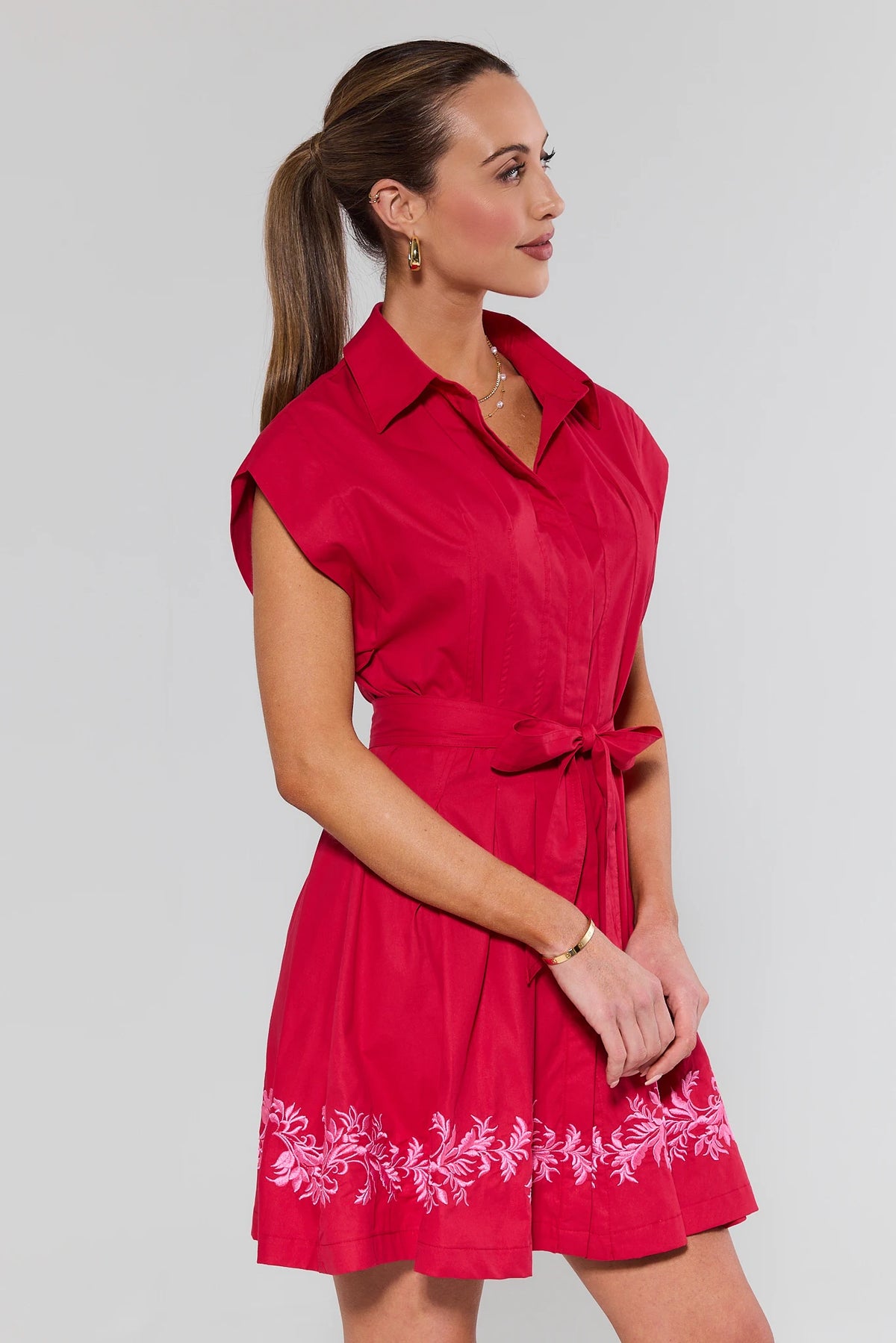 Woman wearing red embroidered short dress with floral hem - Side Profile View | Avara