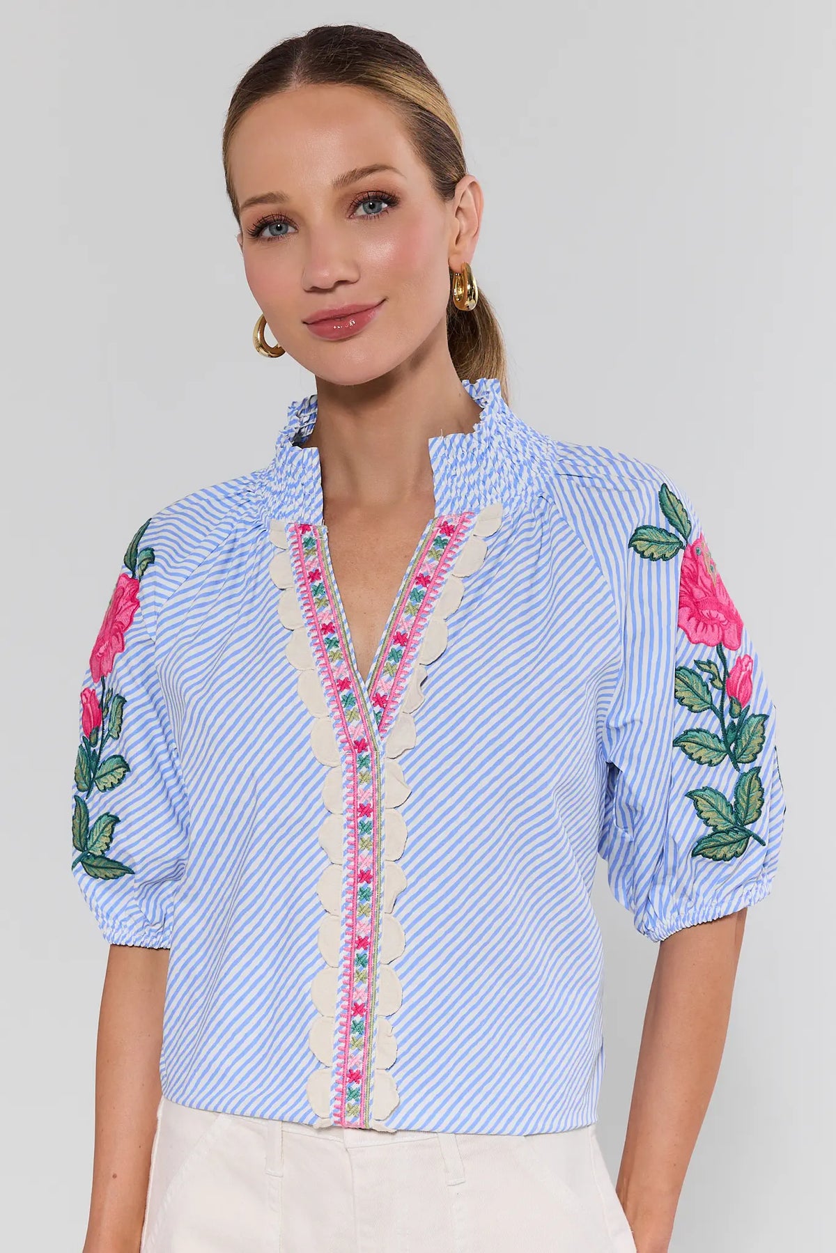 Woman wearing blue striped floral embroidered blouse with scallop trim front detail - Three-Quarter View | Avara